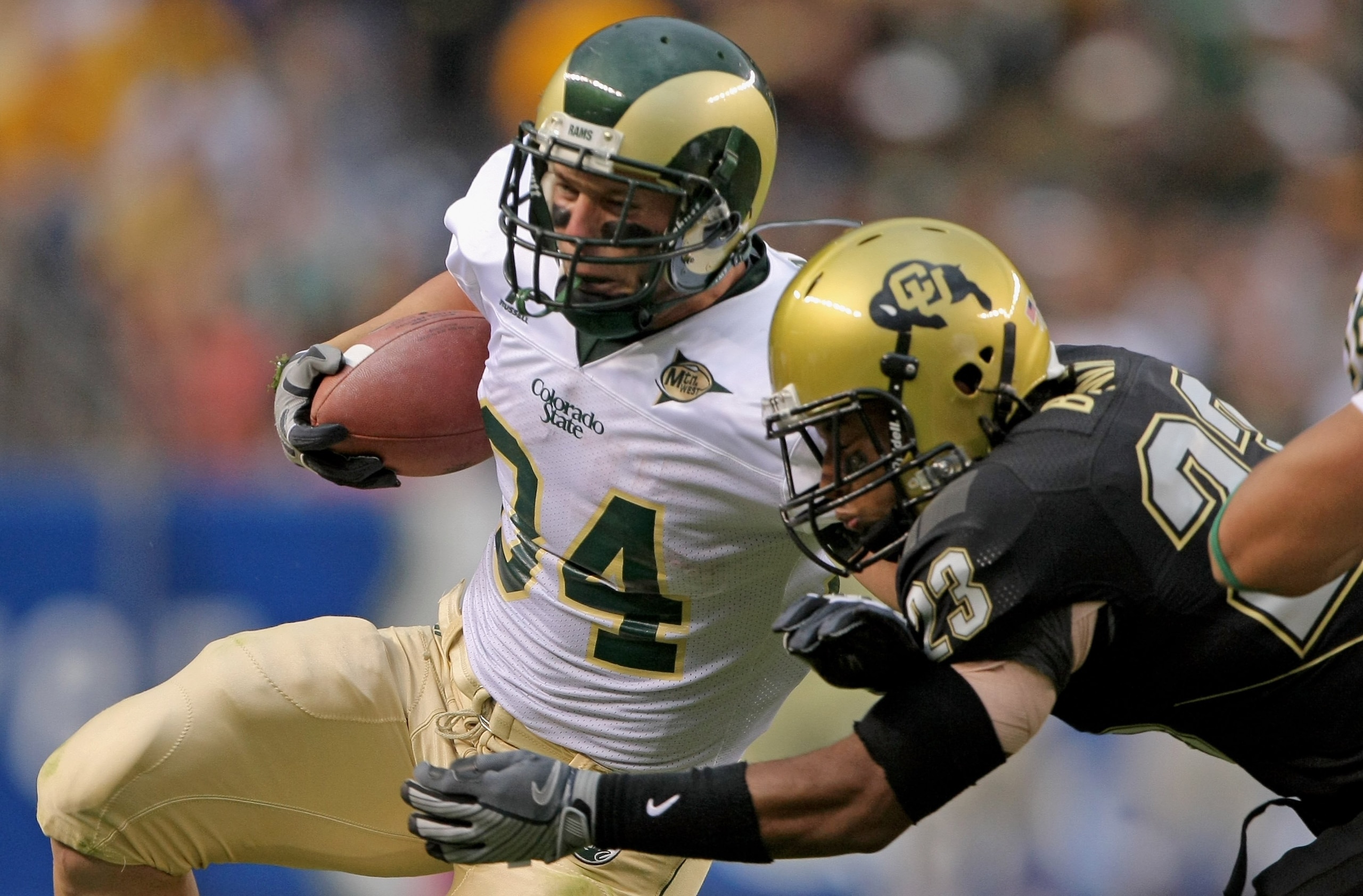 DENVER - AUGUST 31:  Running back Kyle Bell #34 of the Colorado State University Rams rushes and is tackled by Jalil Brown #23 of the University of Colorado Buffaloes at Invesco Field at Mile High on August 31, 2008 in Denver, Colorado. Colorado defeated
