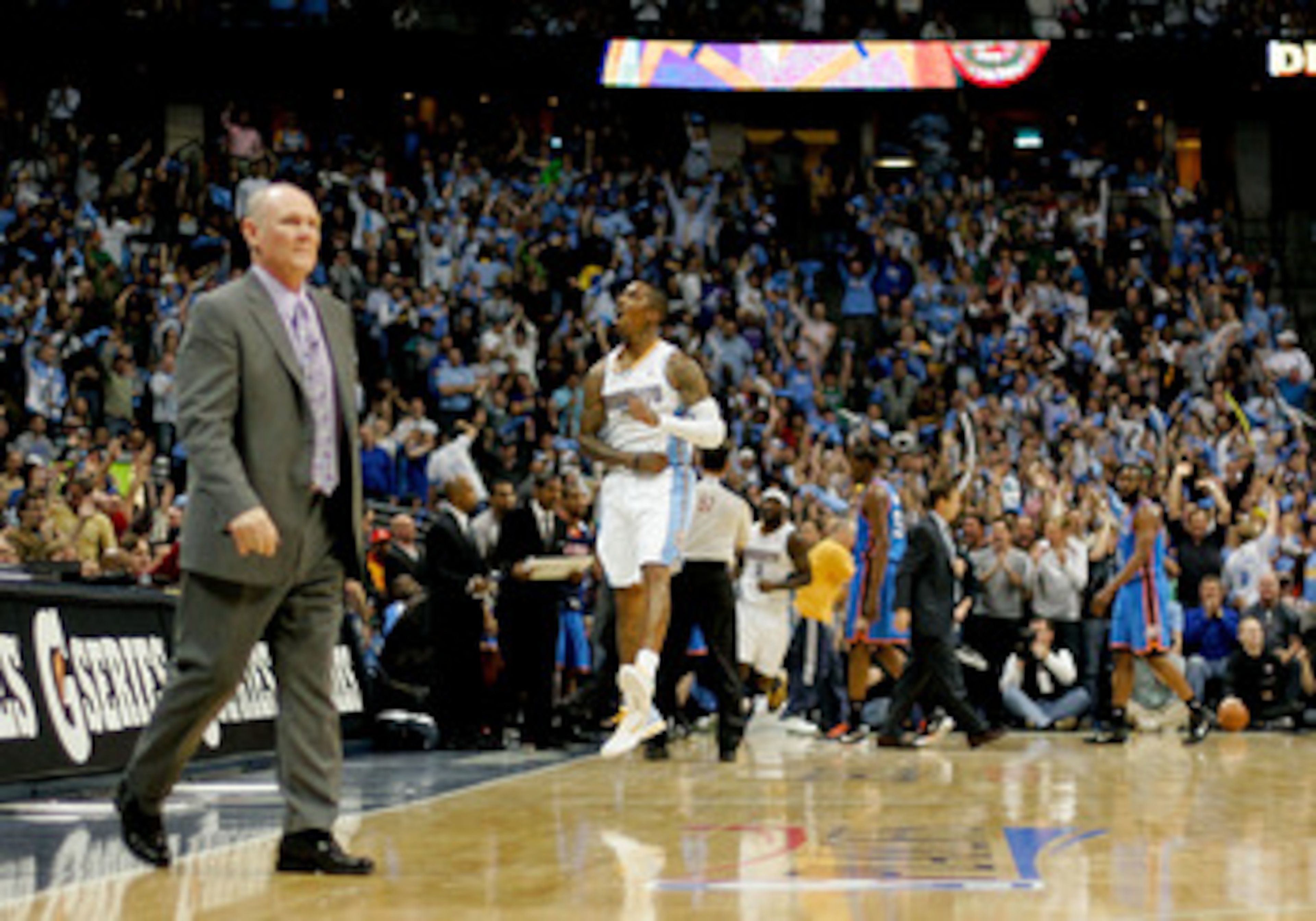 DENVER, CO - APRIL 25:  J.R. Smith #5 of the Denver Nuggets celebrates a three point basket as head coach George Karl walks onto the court for a timeout against the Oklahoma City Thunder in Game Four of the Western Conference Quarterfinals in the 2011 NBA