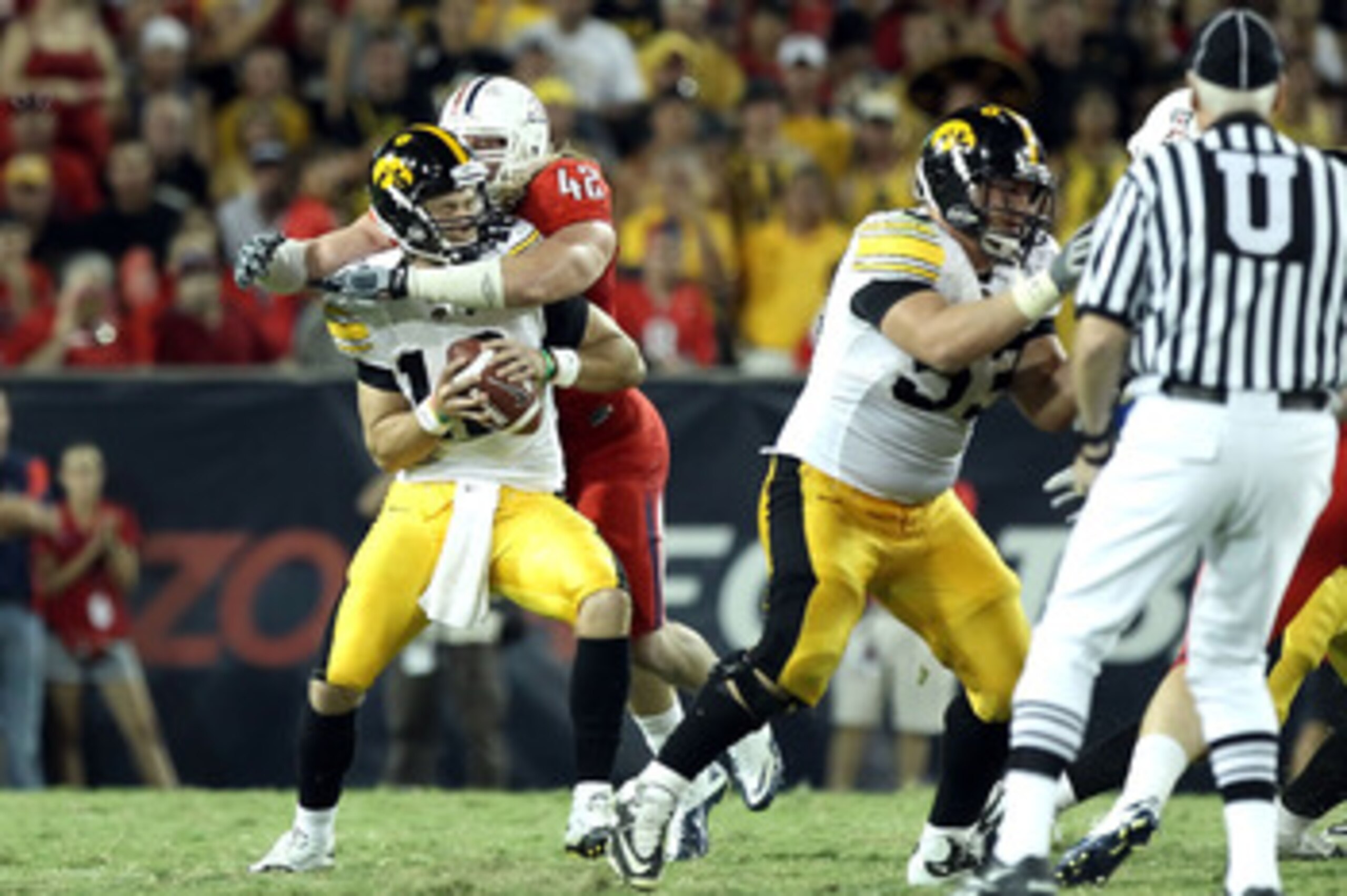 TUCSON, AZ - SEPTEMBER 18:  Quarterback Ricky Stanzi #12 of the Iowa Hawkeyes is sacked by Brooks Reed #42 of the Arizona Wildcats during the third quarter of the college football game at Arizona Stadium on September 18, 2010 in Tucson, Arizona.  The Wild