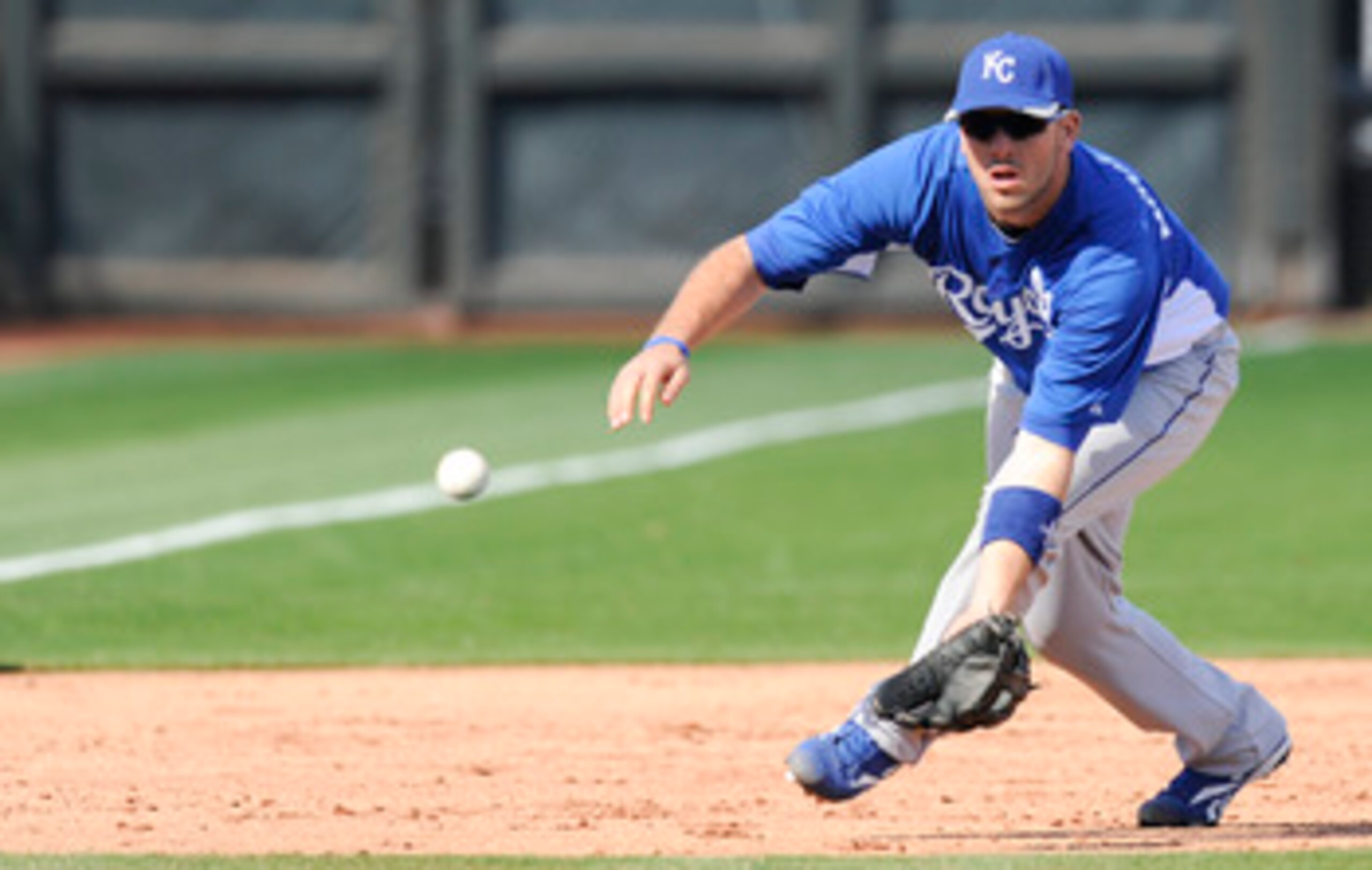 SURPISE, AZ - FEBRUARY 27: Mike Moustakas #8 of the Kansas City Royals field a ground ball during a spring training game against the Texas Rangers at Surprise Stadium on February 27, 2011 in Surprise, Arizona. (Photo by Rob Tringali/Getty Images)