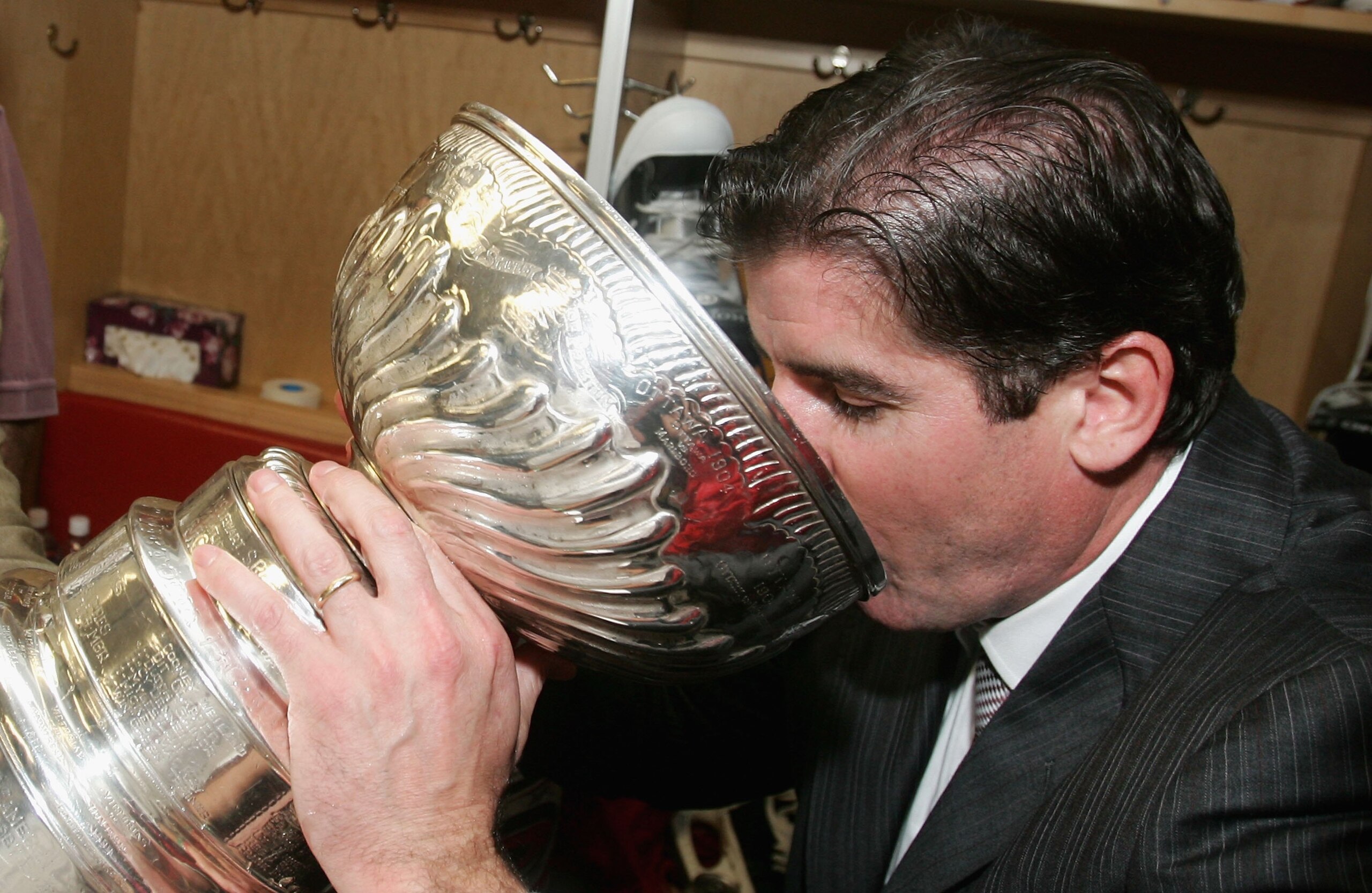 RALEIGH, NC - JUNE 19:  Head coach Peter Laviolette of the Carolina Hurricanes celebrates in the lockerroom drinking from the Stanley Cup after defeating the Edmonton Oilers in game seven of the 2006 NHL Stanley Cup Finals on June 19, 2006 at the RBC Cent