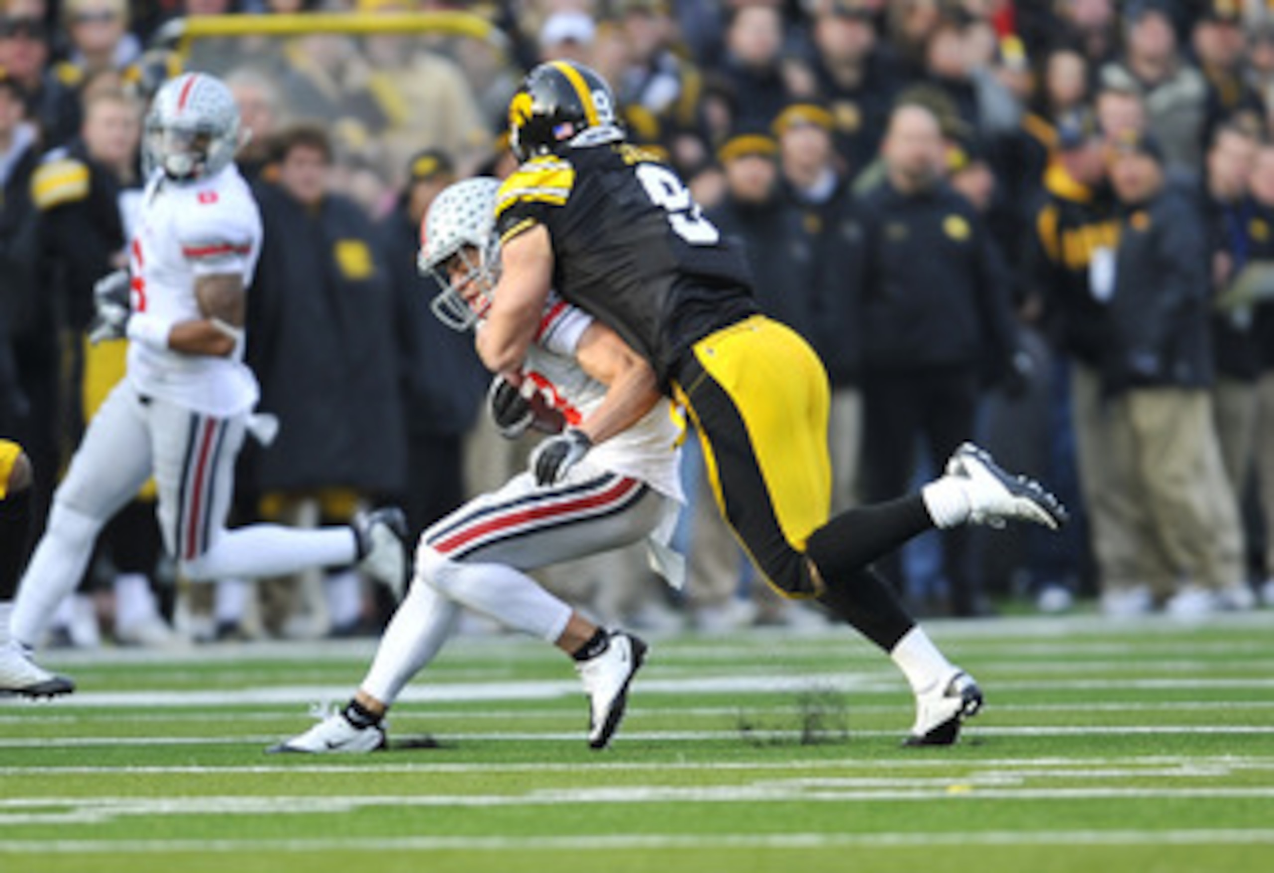 IOWA CITY, IA - NOVEMBER 20: Defensive back Tyler Sash #9 of the University of Iowa Hawkeyes tackles wide receiver Dane Sanzenbacher #12 of the Ohio State Buckeyes during the first half of play at Kinnick Stadium on November 20, 2010 in Iowa City, Iowa. O