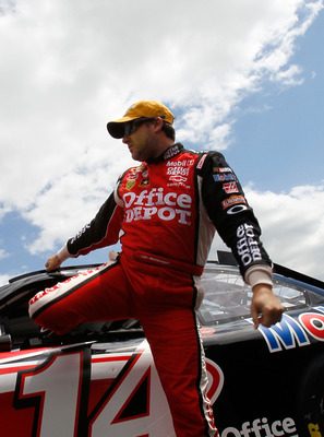 TALLADEGA, AL - APRIL 16:  Tony Stewart, driver of the #14 Office Depot/Mobil 1 Chevrolet, climbs out of his car after qualifying for the NASCAR Sprint Cup Series Aaron's 499 at Talladega Superspeedway on April 16, 2011 in Talladega, Alabama.  (Photo by K