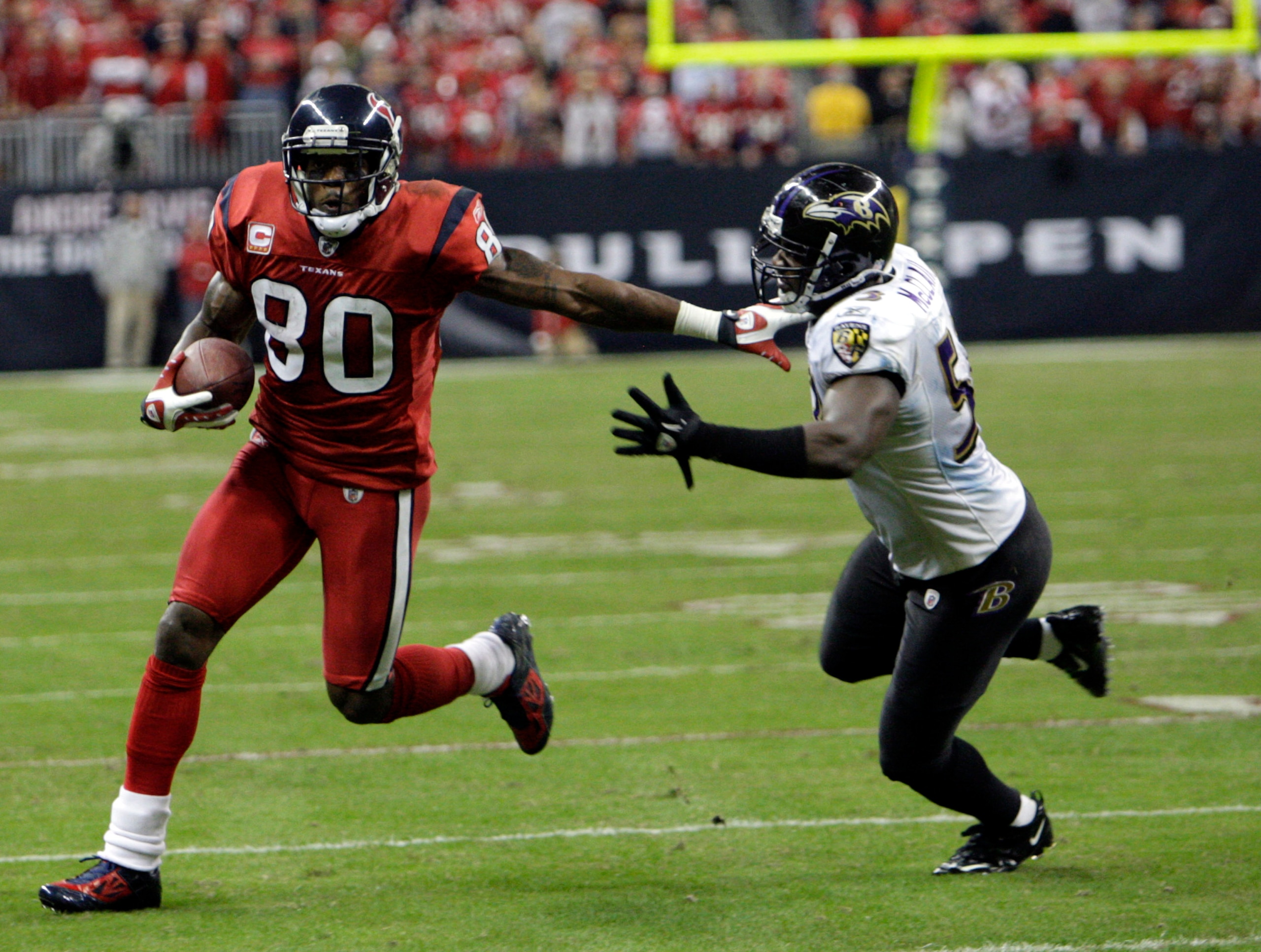 HOUSTON, TX - DECEMBER 13: Wide receiver Andre Johnson #80 of the Houston Texans fends off linebacker Jameel McClain #63 of the Baltimore Ravens as he gains a first down late in the fourth quarter at Reliant Stadium on December 13, 2010 in Houston, Texa HOUSTON, TX - DECEMBER 13: Wide receiver Andre Johnson #80 of the Houston Texans fends off linebacker Jameel McClain #63 of the Baltimore Ravens as he gains a first down late in the fourth quarter at Reliant Stadium on December 13, 2010 in Houston, Texa