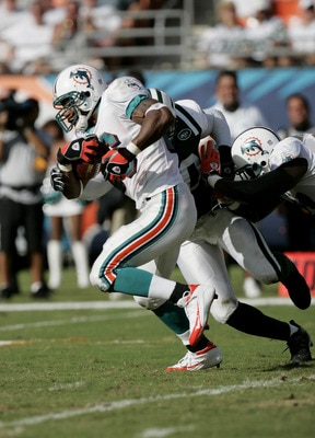 MIAMI - OCTOBER 3: Runningback Leonard Henry #26 of the Miami Dolphins is nearly tackled by the New York Jets during the game at Pro Player Stadium on October 3, 2004 in Miami, Florida. The Jets won 17-9. (Photo by Eliot J. Schechter/Getty Images)