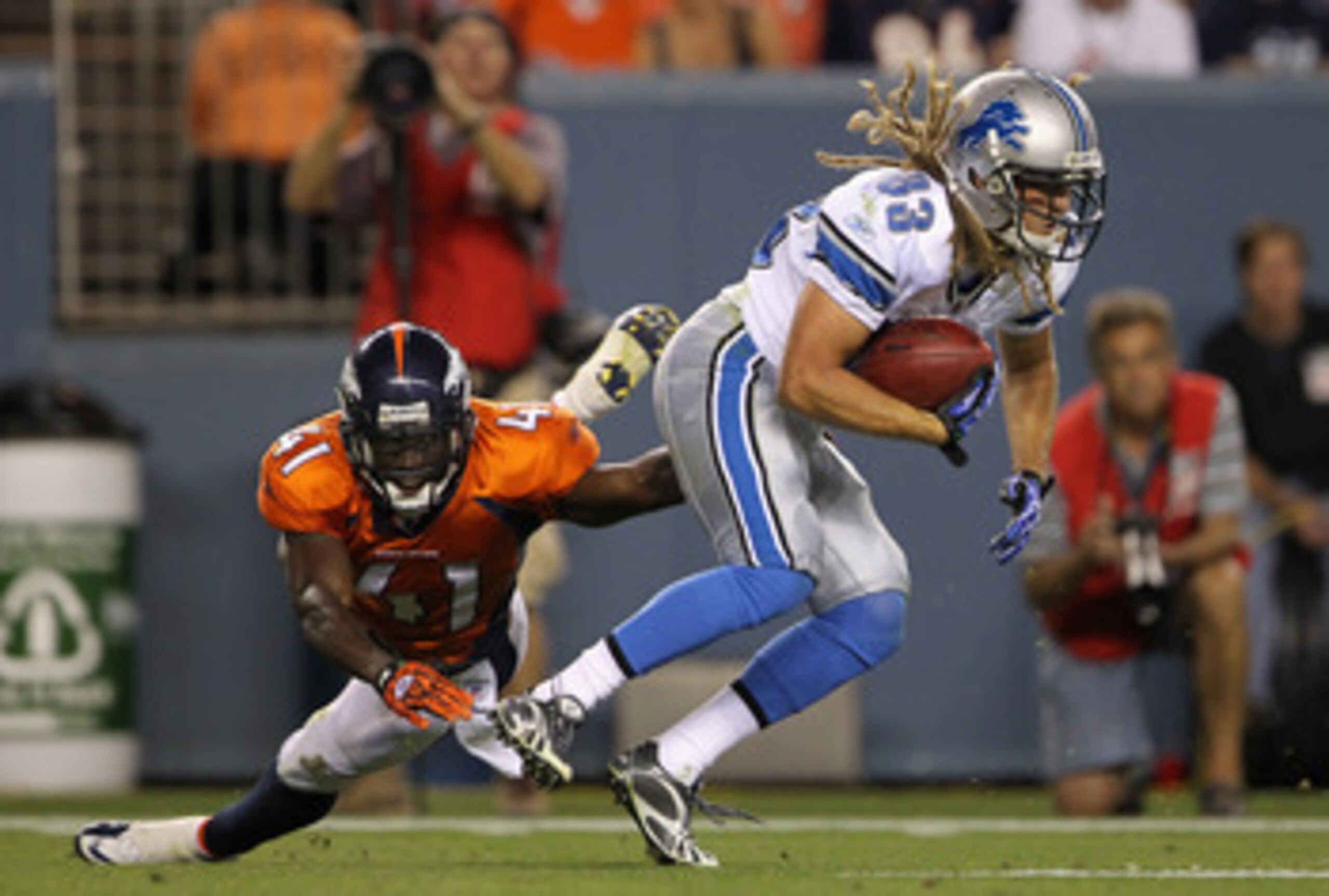 DENVER - AUGUST 21:  Tim Toone #83 of the Detroit Lions eludes the tackle attempt of Cassius Vaughn #41 of the Denver Broncos as he runs back a kick off during preseason NFL action at INVESCO Field at Mile High on August 21, 2010 in Denver, Colorado. The 