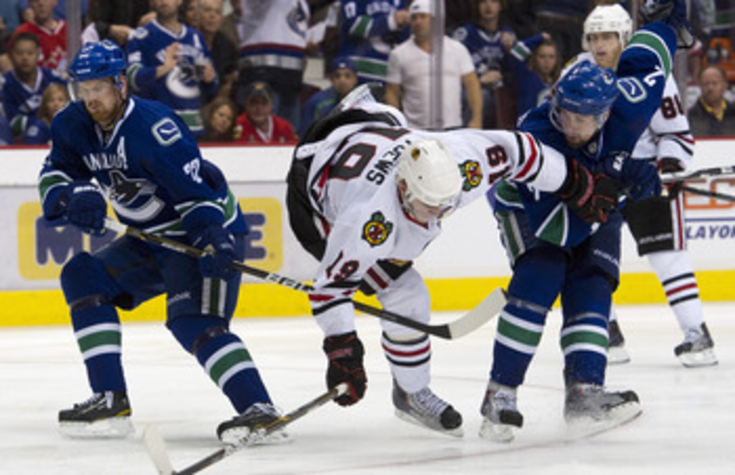 VANCOUVER, CANADA - APRIL 26: Dan Hamhuis #2 of the Vancouver Canucks upends Jonathan Toews #19 of the Chicago Blackhawks during the overtime period in Game Seven of the Western Conference Quarterfinals during the 2011 NHL Stanley Cup Playoffs on April 26