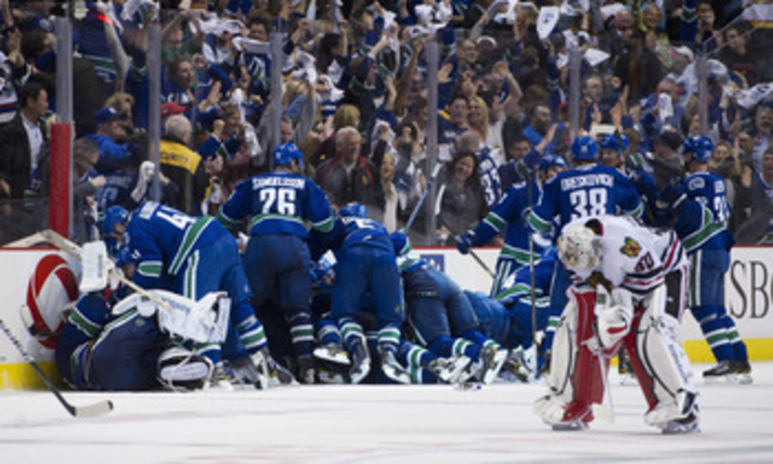 VANCOUVER, CANADA - APRIL 26: The Vancouver Canucks celebrate after defeating the Chicago Blackhawks 2-1 in overtime as goalie Corey Crawford #50 Chicago Blackhawks skates back to his after Game Seven of the Western Conference Quarterfinals during the 201