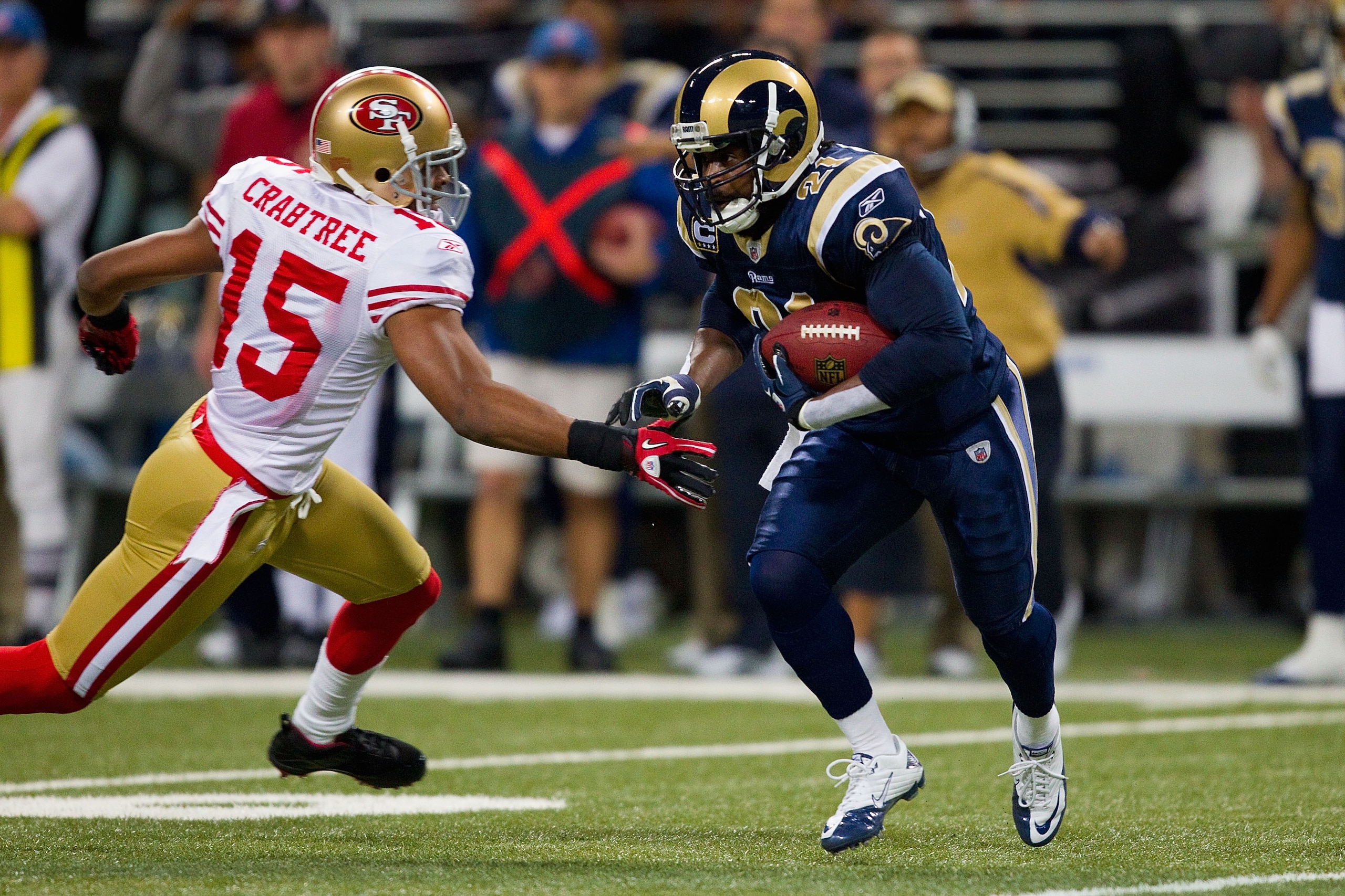 ST. LOUIS, MO - DECEMBER 26: Oshiomogho Atogwe #21 of the St. Louis Rams returns an interception against Michael Crabtree #15 of the San Francisco 49ers at the Edward Jones Dome on December 26, 2010 in St. Louis, Missouri. The Rams beat the 49ers 25-17. (