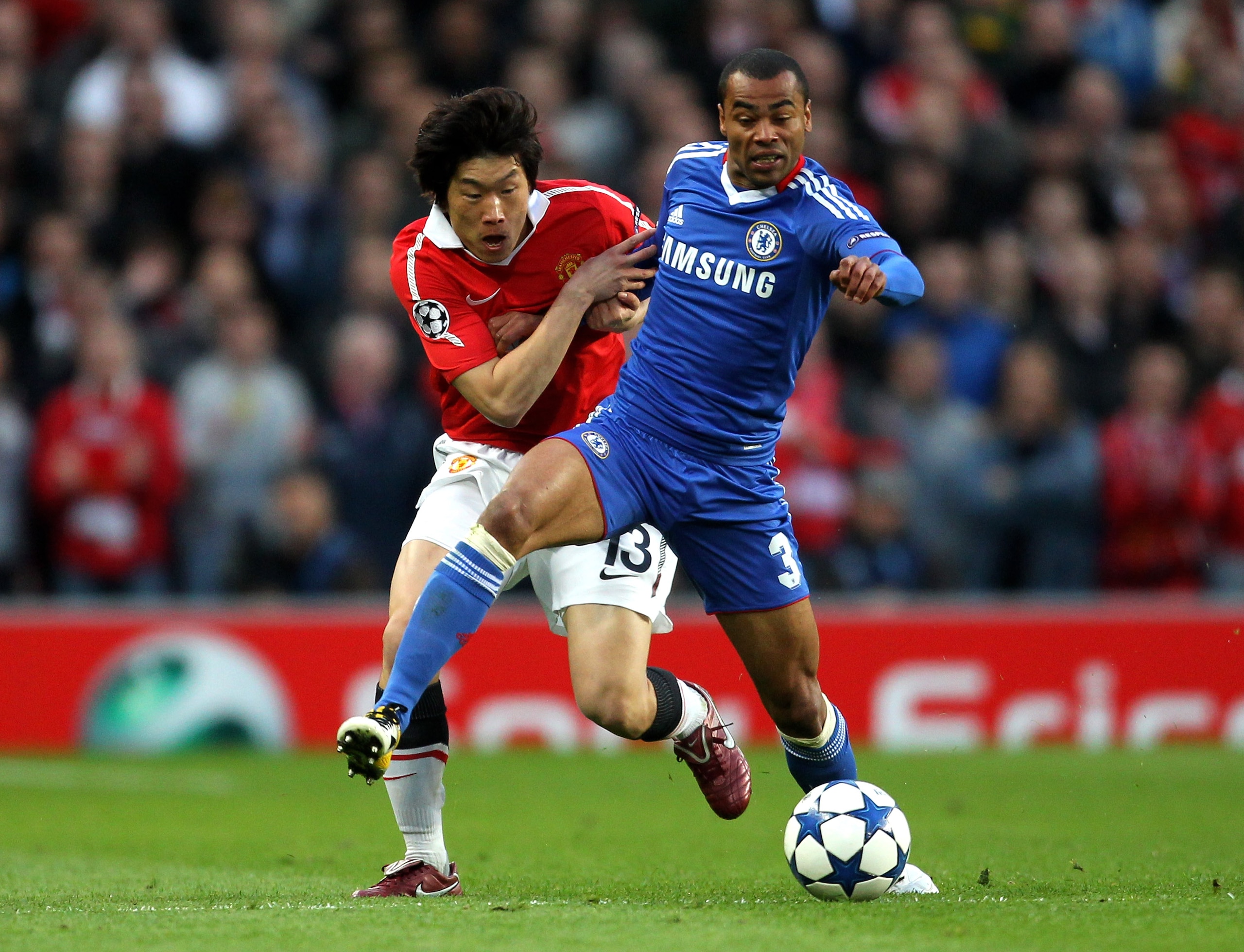 MANCHESTER, ENGLAND - APRIL 12:  Ashley Cole of Chelsea tussles for posession with Ji-Sung Park of Manchester United during the UEFA Champions League Quarter Final second leg match between Manchester United and Chelsea at Old Trafford on April 12, 2011 in