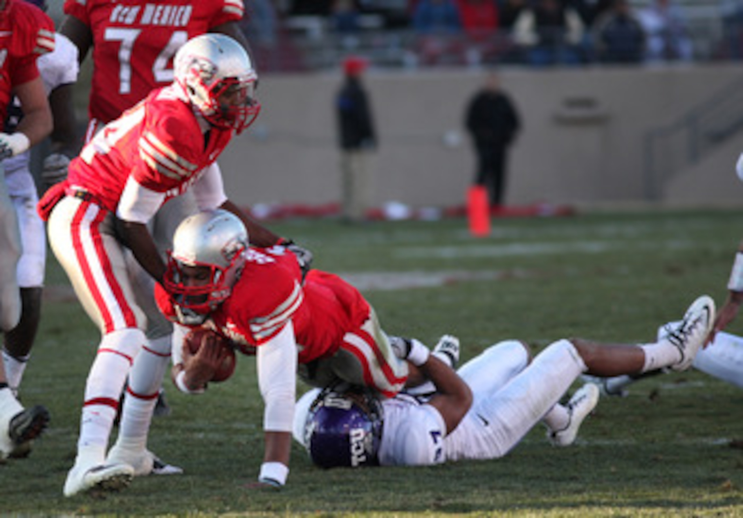 ALBUQUERQUE, NM - NOVEMBER 27: Quarterback Stump Godfrey #11 of the University of New Mexico Lobos is tackled by Jason Teague #27 of the TCU Horned Frogs on November 27, 2010 at University Stadium in Albuquerque, New Mexico. TCU won 66-17. (Photo by Eric 
