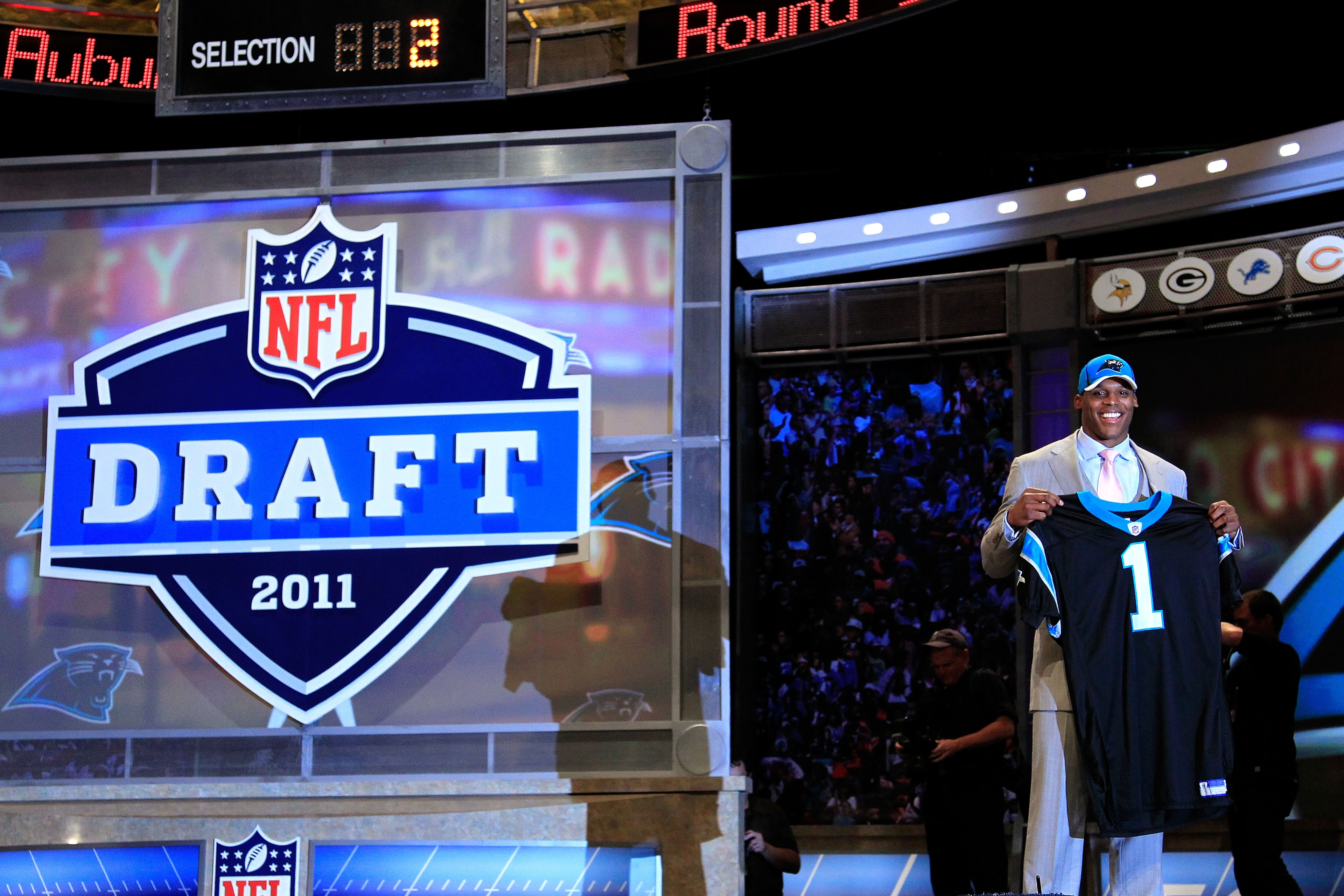 NEW YORK, NY - APRIL 28: Cam Newton, #1 overall pick by the Carolina Panthers holds up a jersey on stage after he was picked during the 2011 NFL Draft at Radio City Music Hall on April 28, 2011 in New York City. (Photo by Chris Trotman/Getty Images) NEW YORK, NY - APRIL 28: Cam Newton, #1 overall pick by the Carolina Panthers holds up a jersey on stage after he was picked during the 2011 NFL Draft at Radio City Music Hall on April 28, 2011 in New York City. (Photo by Chris Trotman/Getty Images)