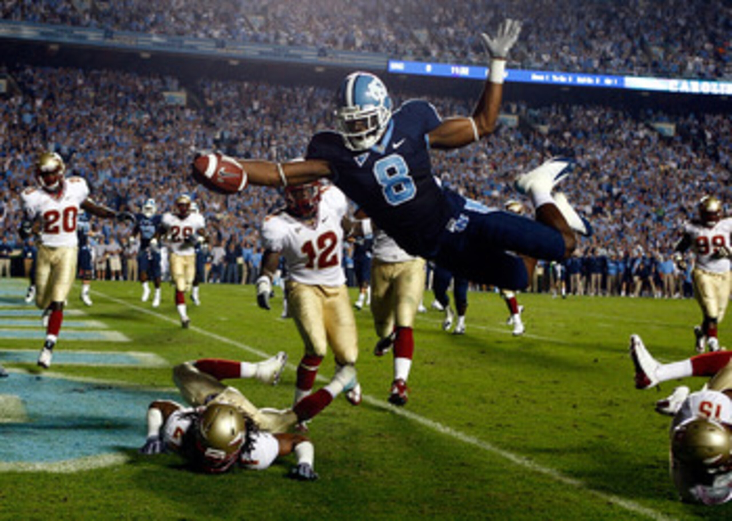 CHAPEL HILL, NC - OCTOBER 22:  Greg Little #8 of the North Carolina Tar Heels dives past Florida State Seminole defenders Patrick Robinson #21, Nigel Carr #12 and Ochuko Jenije #15 for a first quarter touchdown at Kenan Stadium on October 22, 2009 in Chap
