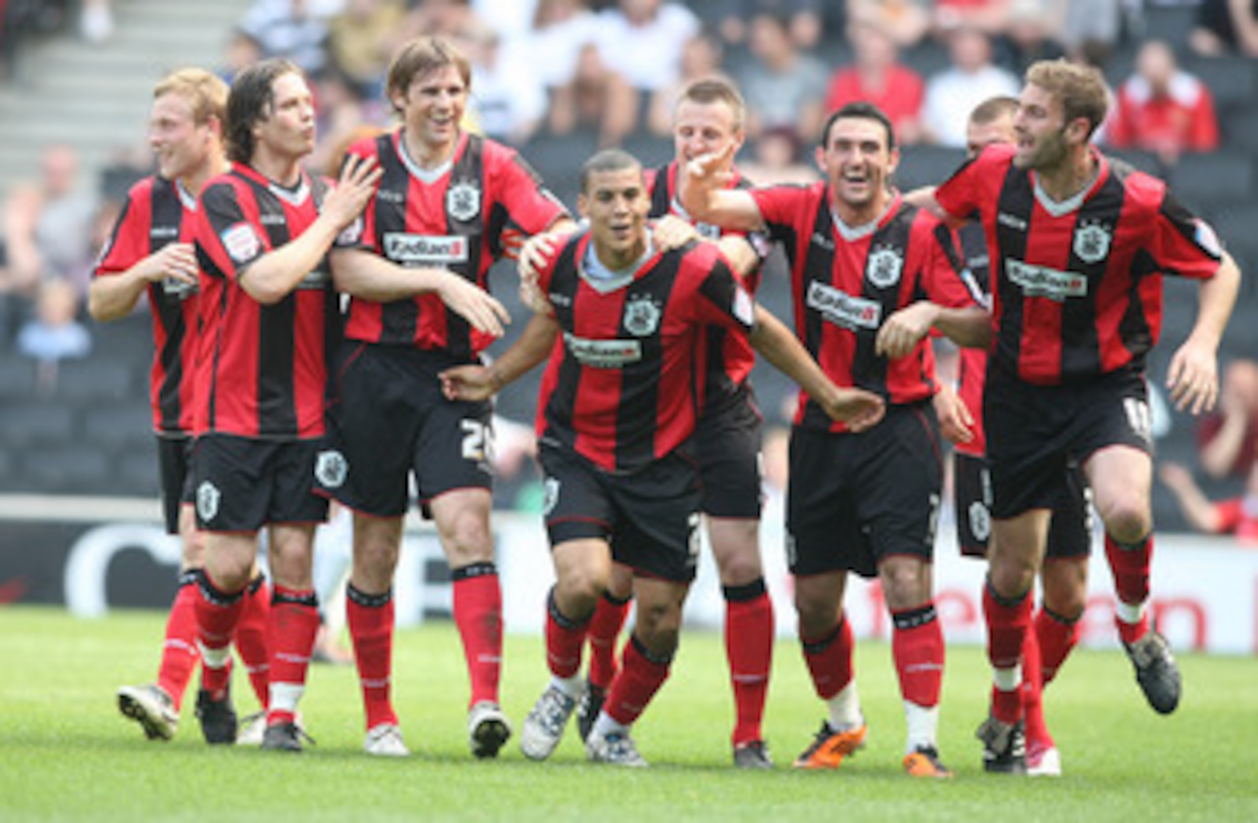 MILTON KEYNES, ENGLAND - APRIL 22: Lee Peltier (2) of Huddersfield Town is congratulated by team mates after scoring his sides second goal during the npower League One match between MK Dons and Huddersfield Town at Stadium mk on April 22, 2011 in Milton K