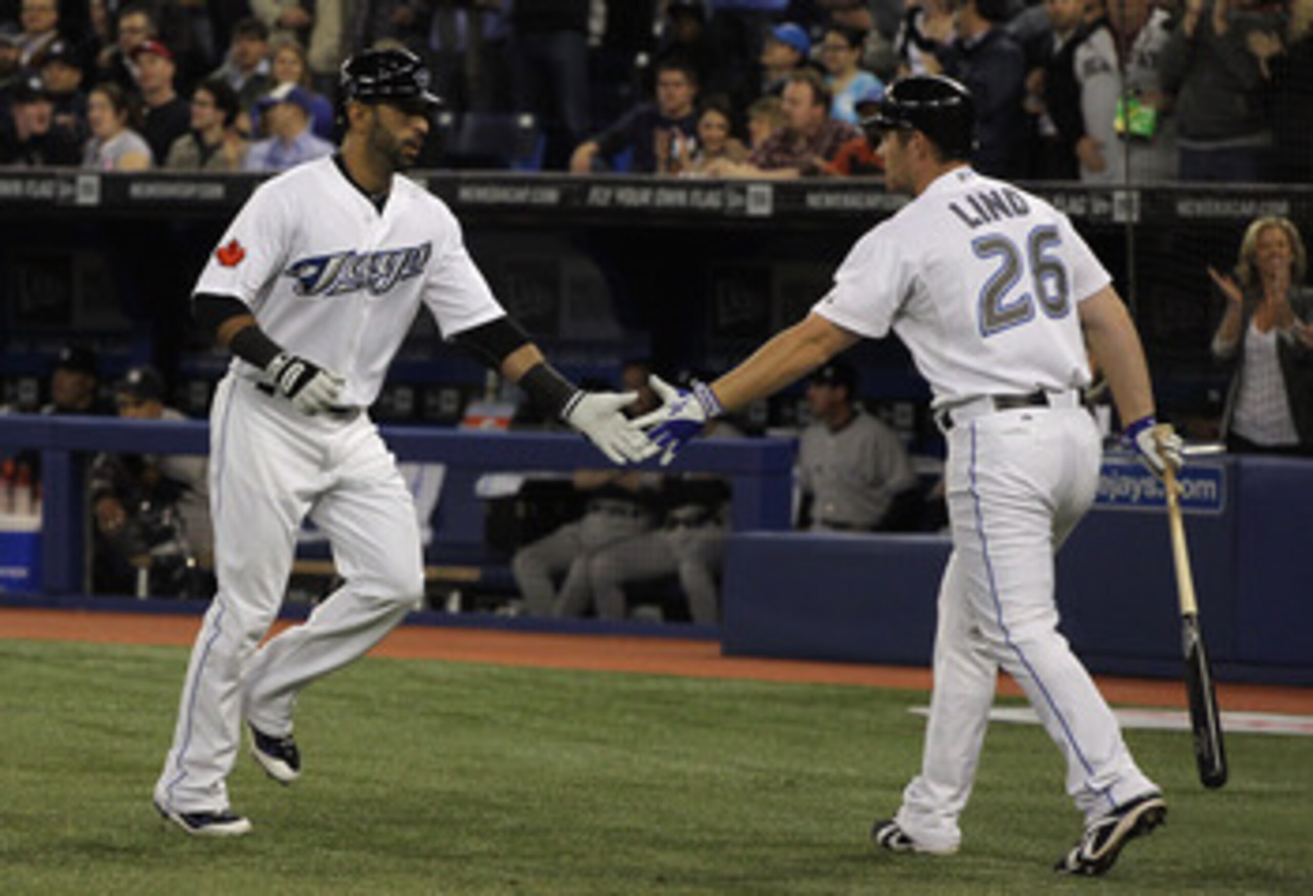TORONTO, ON - APRIL 19:  Jose Bautista #19 (L) of the Toronto Blue Jays celebrates with teammate Adam Lind #26 after Bautista's first inning home run during their game against the New York Yankees at Rogers Centre on April 19, 2011 in Toronto, Canada.  (P