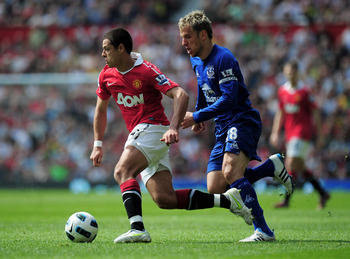 MANCHESTER, ENGLAND - APRIL 23:  Javier Hernandez of Manchester United skips past Phil Neville of Everton during the Barclays Premier League match between Manchester United and Everton at Old Trafford on April 23, 2011 in Manchester, England.  (Photo by S