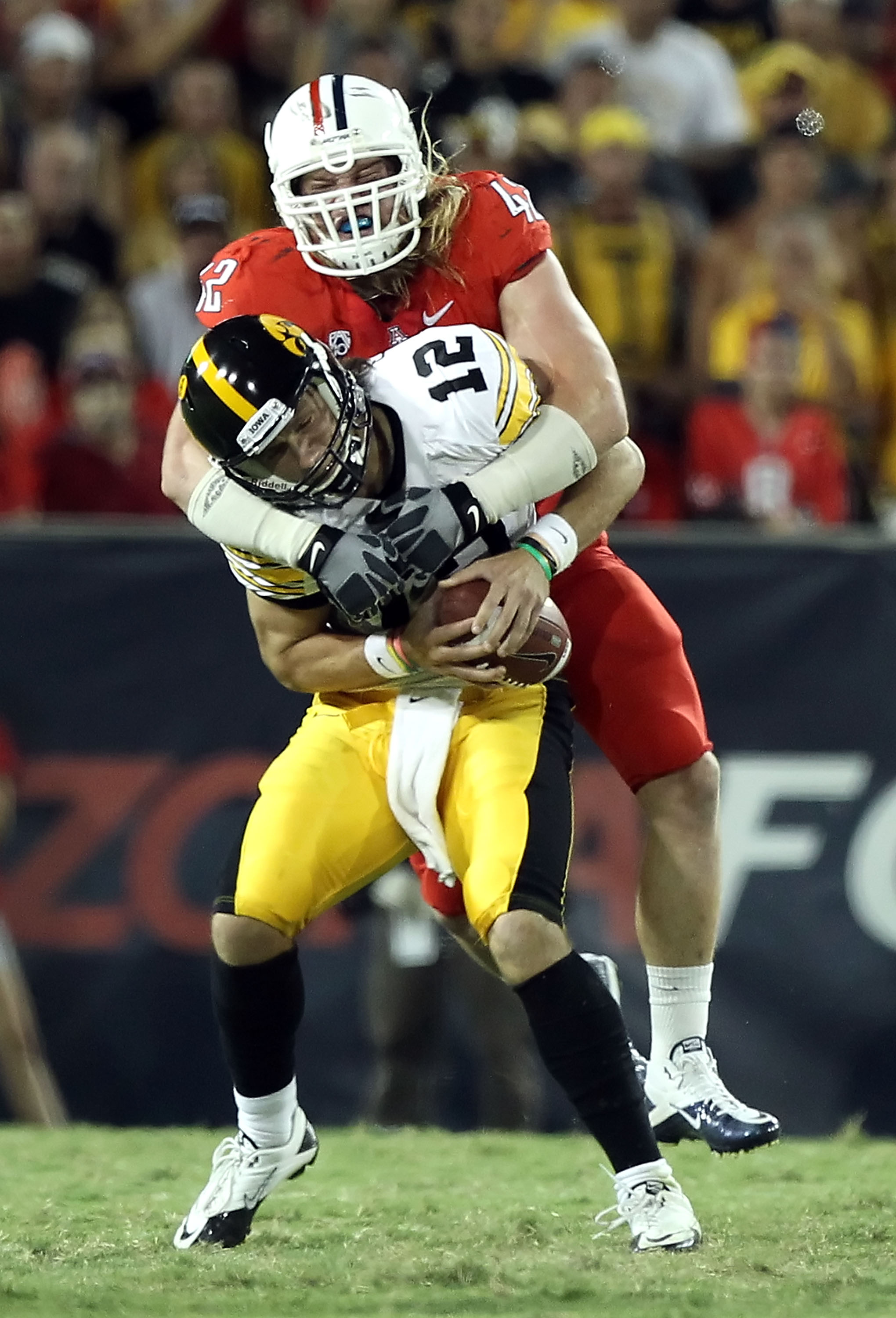TUCSON, AZ - SEPTEMBER 18:  Quarterback Ricky Stanzi #12 of the Iowa Hawkeyes is sacked by Brooks Reed #42 of the Arizona Wildcats during the third quarter of the college football game at Arizona Stadium on September 18, 2010 in Tucson, Arizona.  The Wild