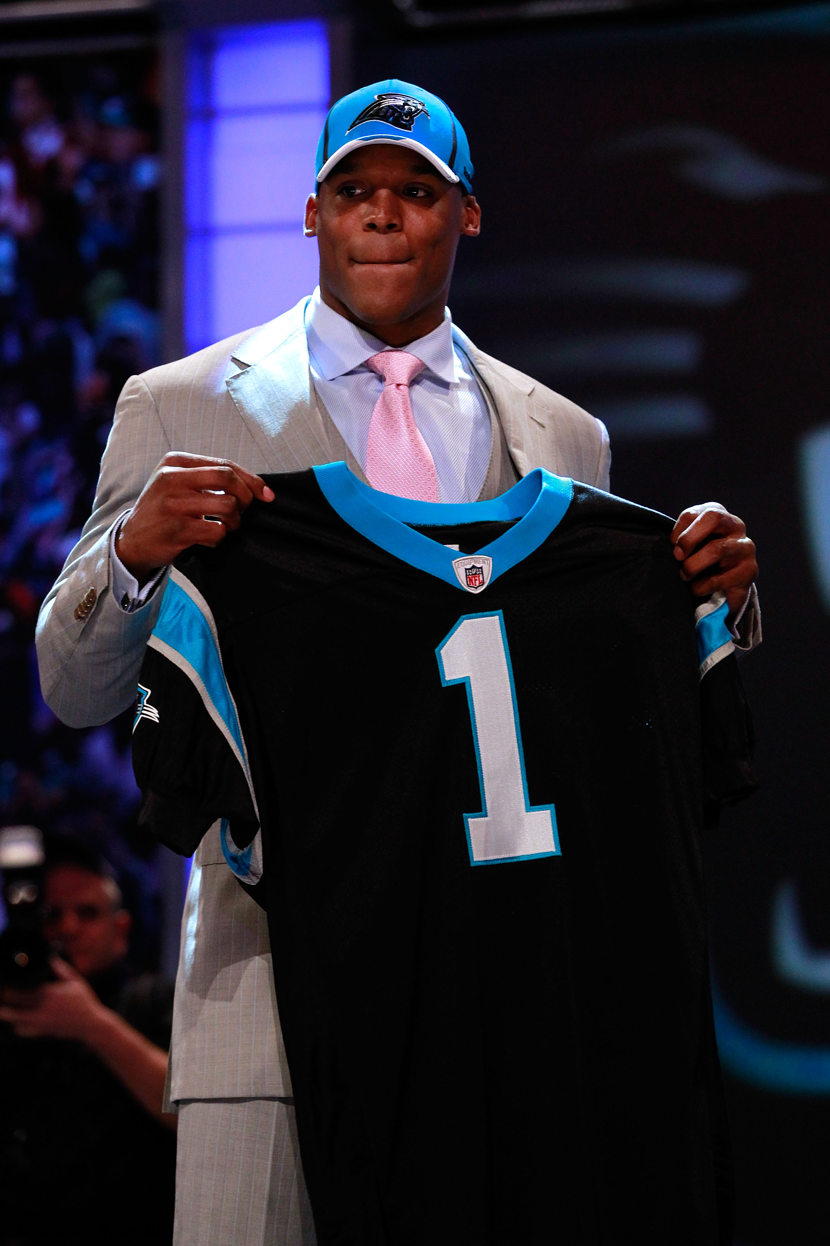 NEW YORK, NY - APRIL 28:  Cam Newton, #1 overall pick by the Carolina Panthers holds up a jersey on stage after he was picked during the 2011 NFL Draft at Radio City Music Hall on April 28, 2011 in New York City.  (Photo by Chris Trotman/Getty Images)