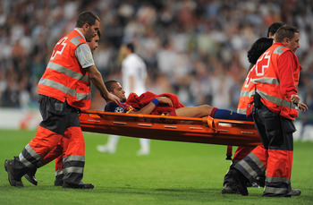 MADRID, SPAIN - APRIL 27:  Daniel Alves of Barcelona is stretchered off the pitch after being fouled by Pepe of Real Madrid during the UEFA Champions League Semi Final first leg match between Real Madrid and Barcelona at the Estadio Santiago Bernabeu on A