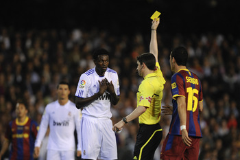 VALENCIA, SPAIN - APRIL 20:  Referee Alberto Undiano Mallenco shows the yellow card to Adebayor of Real Madrid (L) during the Copa del Rey Final between Real Madrid and Barcelona at Estadio Mestalla on April 20, 2011 in Valencia, Spain.  (Photo by David R