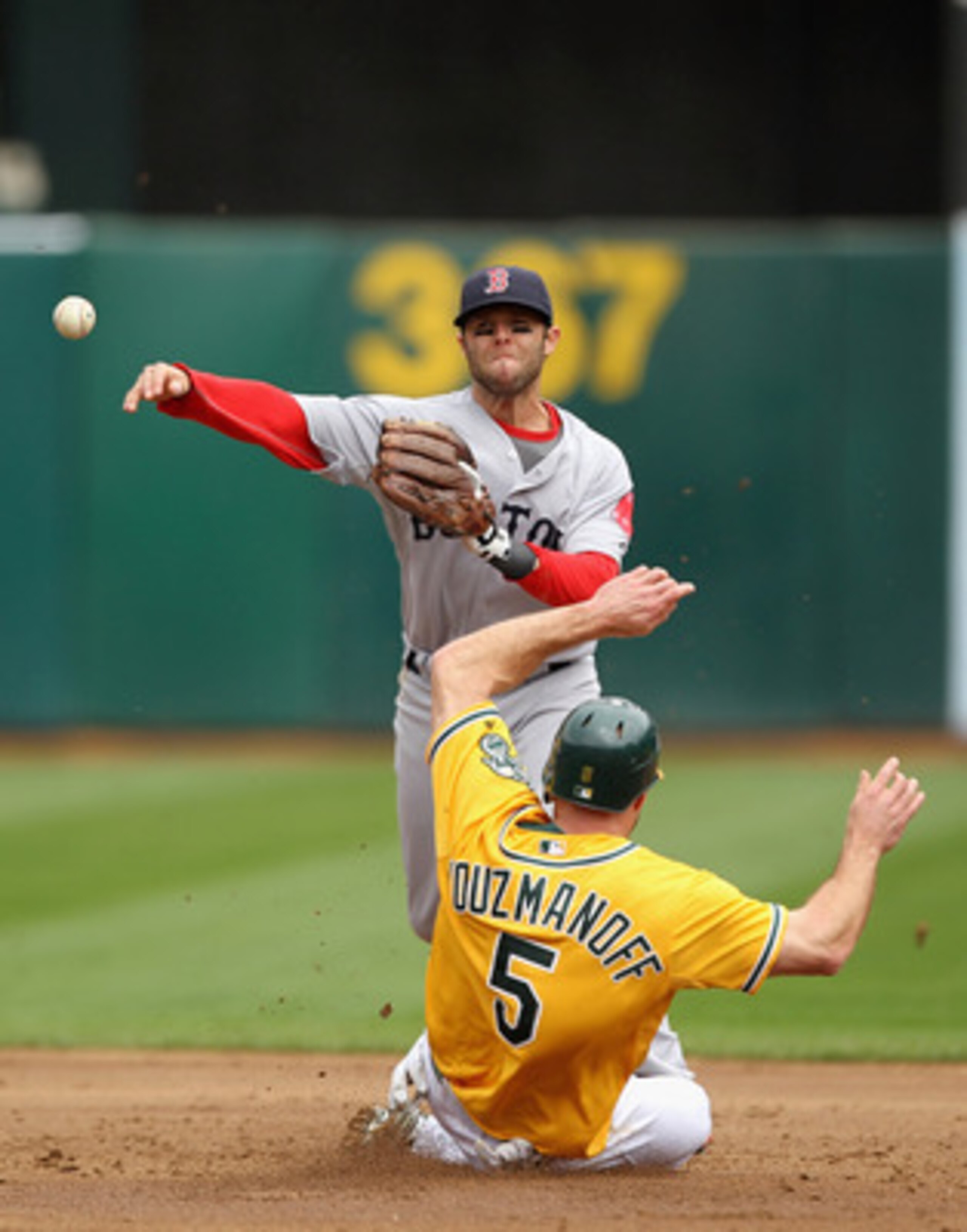 OAKLAND, CA - APRIL 20: Dustin Pedroia #15 of the Boston Red Sox tries to turn a double play while Kevin Kouzmanoff #5 of the Oakland Athletics slides in to second base at Oakland-Alameda County Coliseum on April 20, 2011 in Oakland, California.  (Photo b