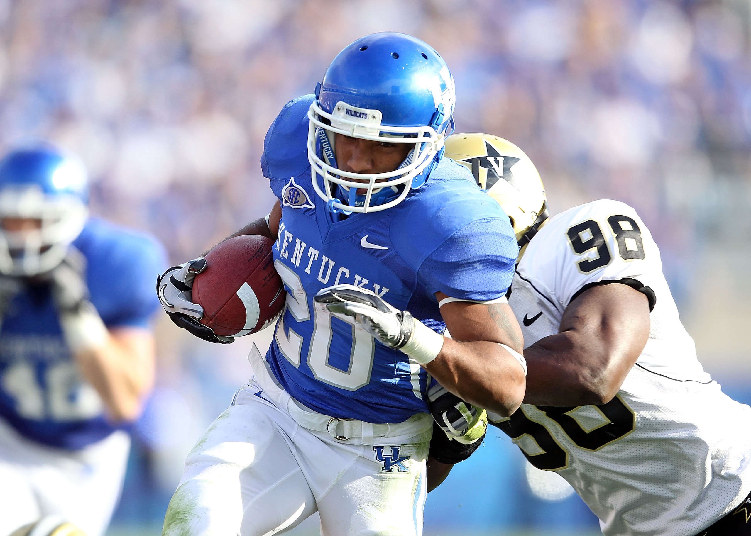LEXINGTON, KY - NOVEMBER 13: Derrick Locke #20 of the Kentucky Wildcats runs with the ball while defended by Johnell Thomas #98 of the Vanderbilt Commodores during the game at Commonwealth Stadium on November 13, 2010 in Lexington, Kentucky. Kentucky won