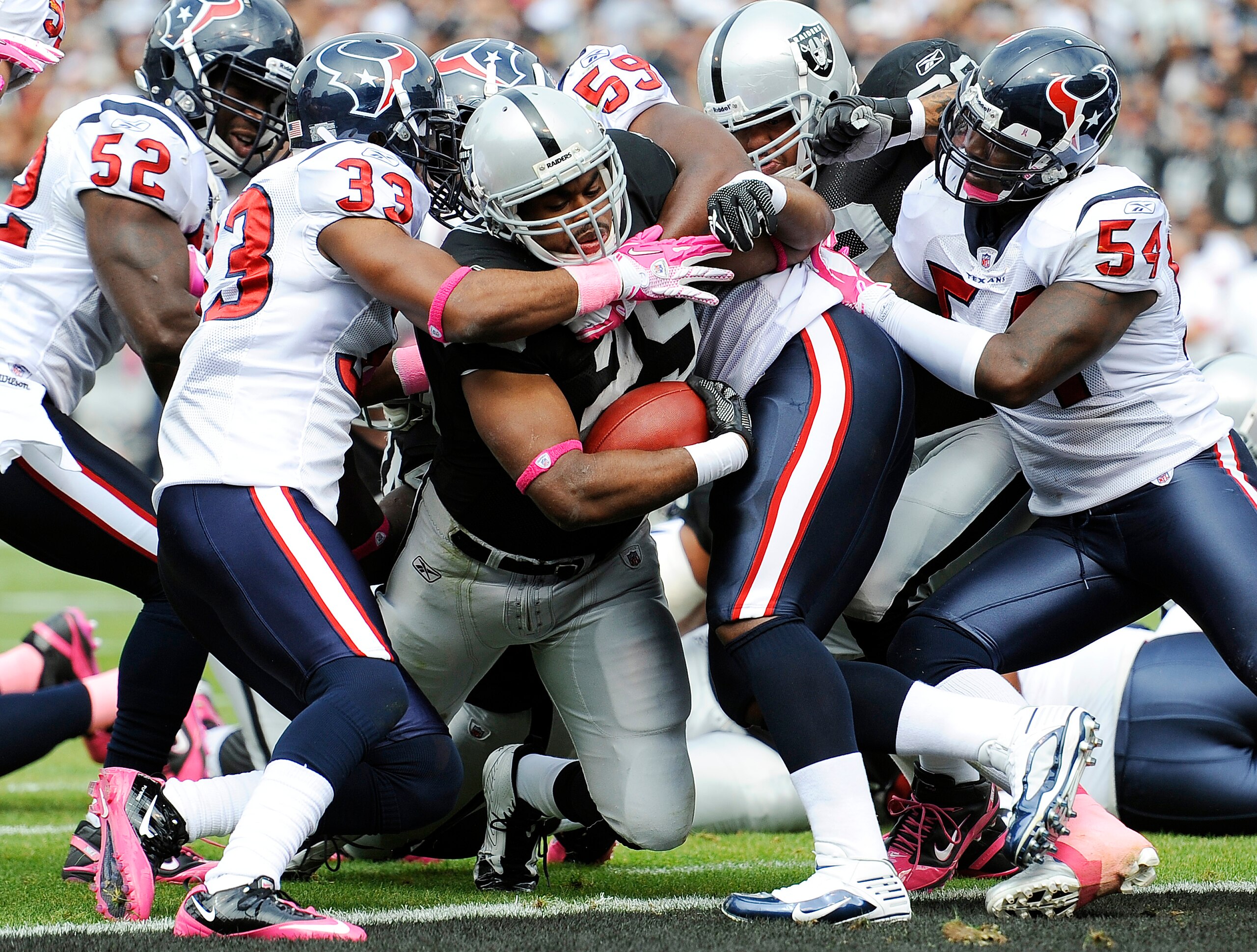 OAKLAND, CA - OCTOBER 3: Running back Michael Bush #29 of the Oakland Raiders drags Troy Nolan #33 and DeMeco Ryans #59 of the Houston Texans into the endzone for a touchdown during an NFL football game October 3, 2010 at The Oakland-Alameda County Colise