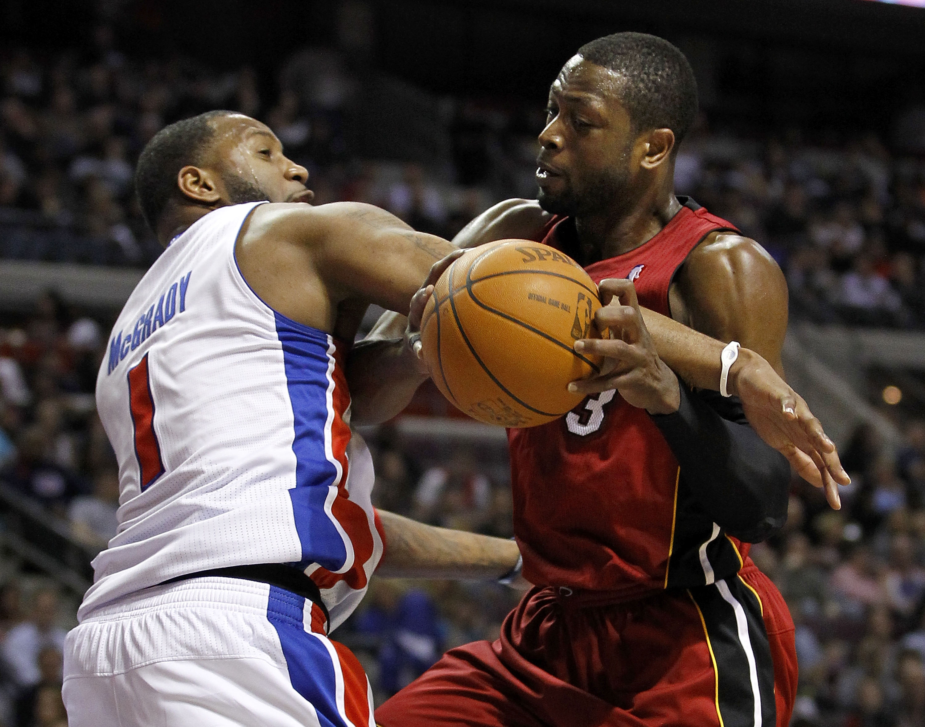 AUBURN HILLS, MI - MARCH 23:  Dwyane Wade #3 of the Miami Heat gets fouled by Tracy McGrady #1 of the Detroit Pistons at The Palace of Auburn Hills on March 23, 2011 in Auburn Hills, Michigan. Miami won the game 100-94. NOTE TO USER: User expressly acknow