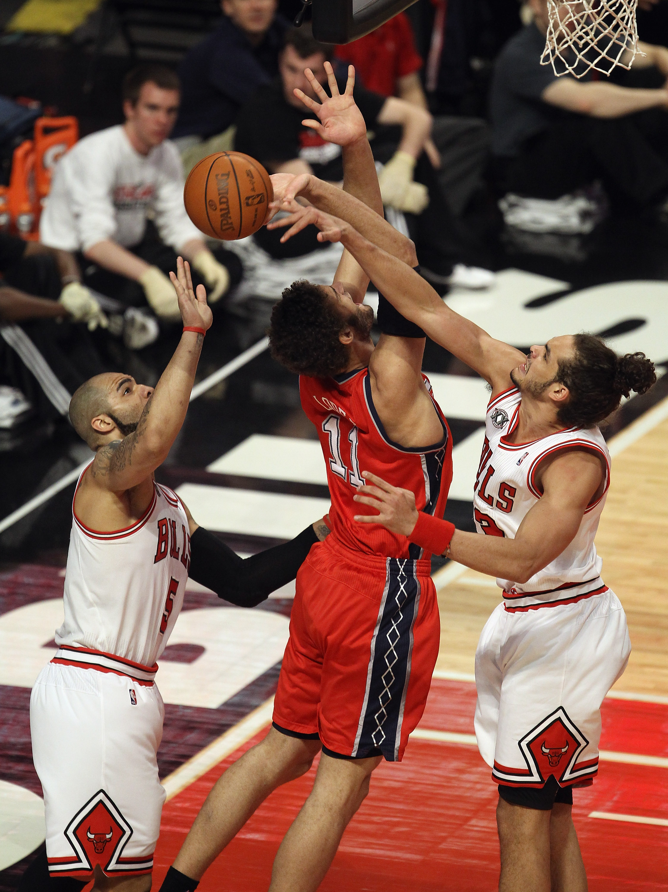 CHICAGO, IL - APRIL 13: Joakim Noah #13 of the Chicago Bulls blocks a shot by Brook Lopez #11 of the New Jersey Nets as Carlos Boozer #5 reaches for the ball at United Center on April 13, 2011 in Chicago, Illinois. NOTE TO USER: User expressly acknowledge