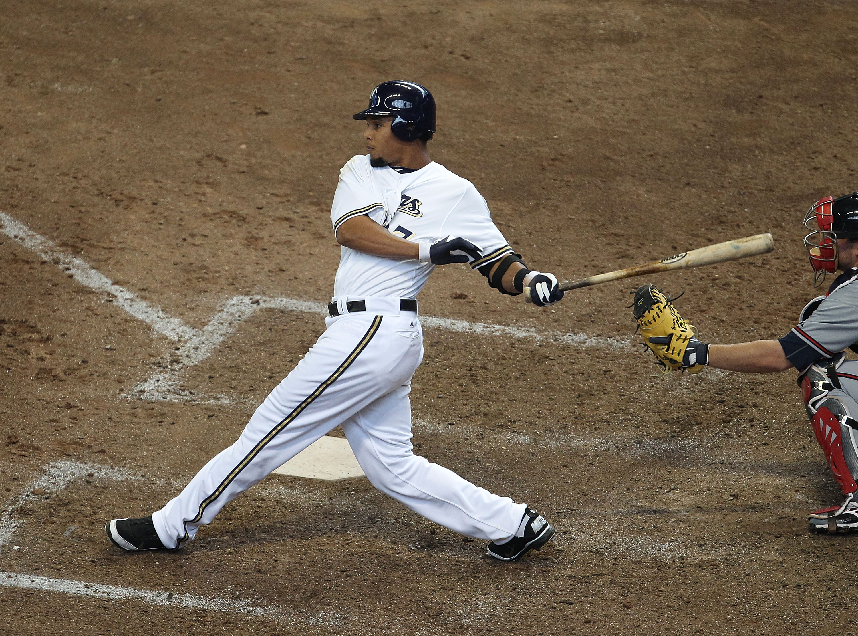 MILWAUKEE, WI - APRIL 04: Carlos Gomez #27 of the Milwaukee Brewers hits the ball against the Atlanta Braves during the home opener at Miller Park on April 4, 2011 in Milwaukee, Wisconsin. The Braves defeated the Brewers 2-1. (Photo by Jonathan Daniel/Get