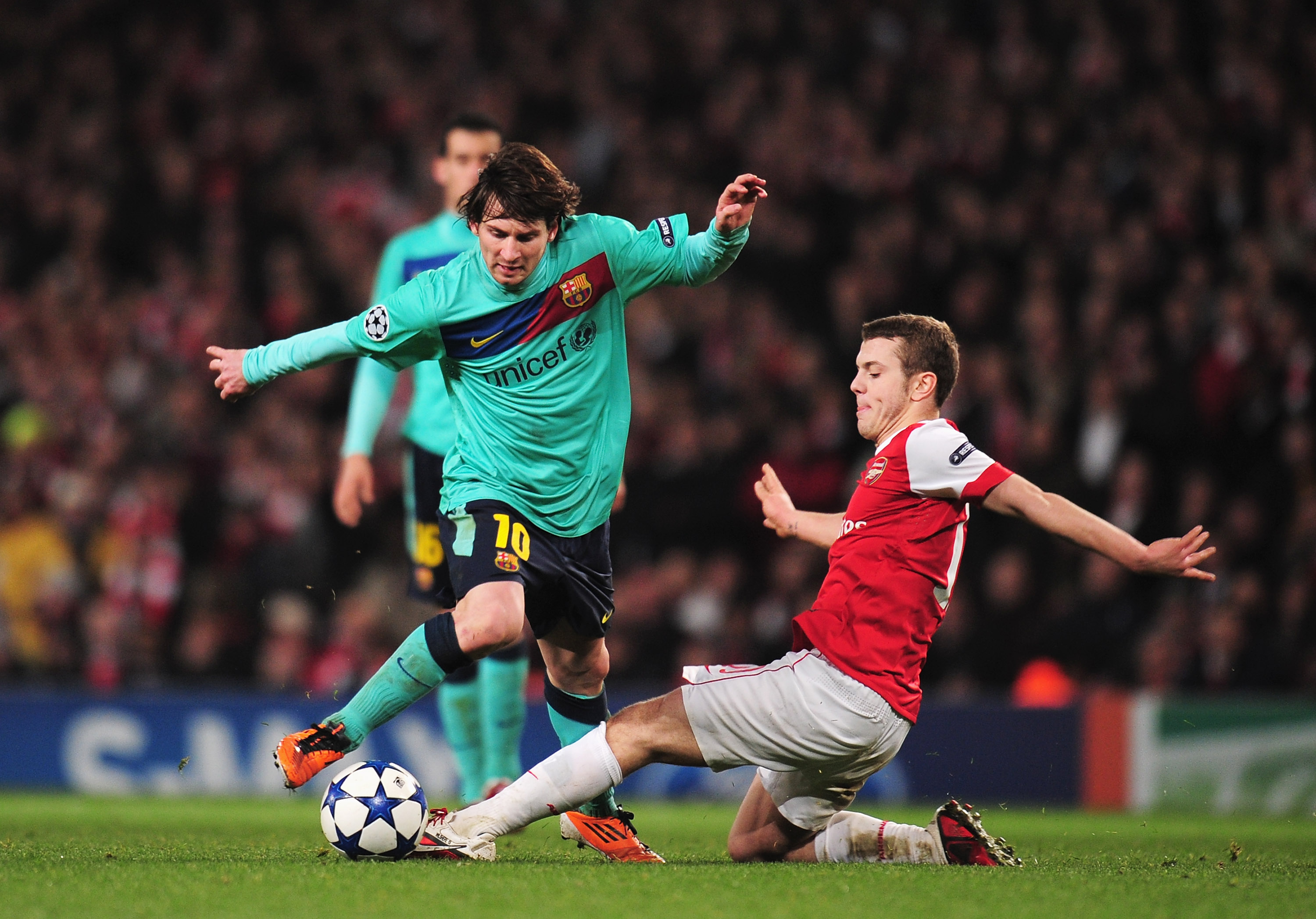 LONDON, ENGLAND - FEBRUARY 16: Lionel Messi of Barcelona is challenged by  Jack Wilshere of Arsenal   during the UEFA Champions League round of 16 first leg match between Arsenal and Barcelona at the Emirates Stadium on February 16, 2011 in London, Englan