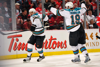 DETROIT - MAY 4:  Devin Setoguchi #16 of the San Jose Sharks celebrates his first period power play goal against the Detroit Red Wings with teammate Joe Thornton #19 of the San Jose Sharks in Game Three of the Western Conference Semifinals during the 2011