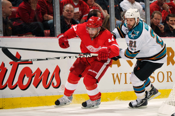 DETROIT - MAY 4:  Patrick Eaves #17 of the Detroit Red Wings and Scott Nichol #21 of the San Jose Sharks battle for position as they chase down a loose puck in the second period in Game Three of the Western Conference Semifinals during the 2011 NHL Stanle