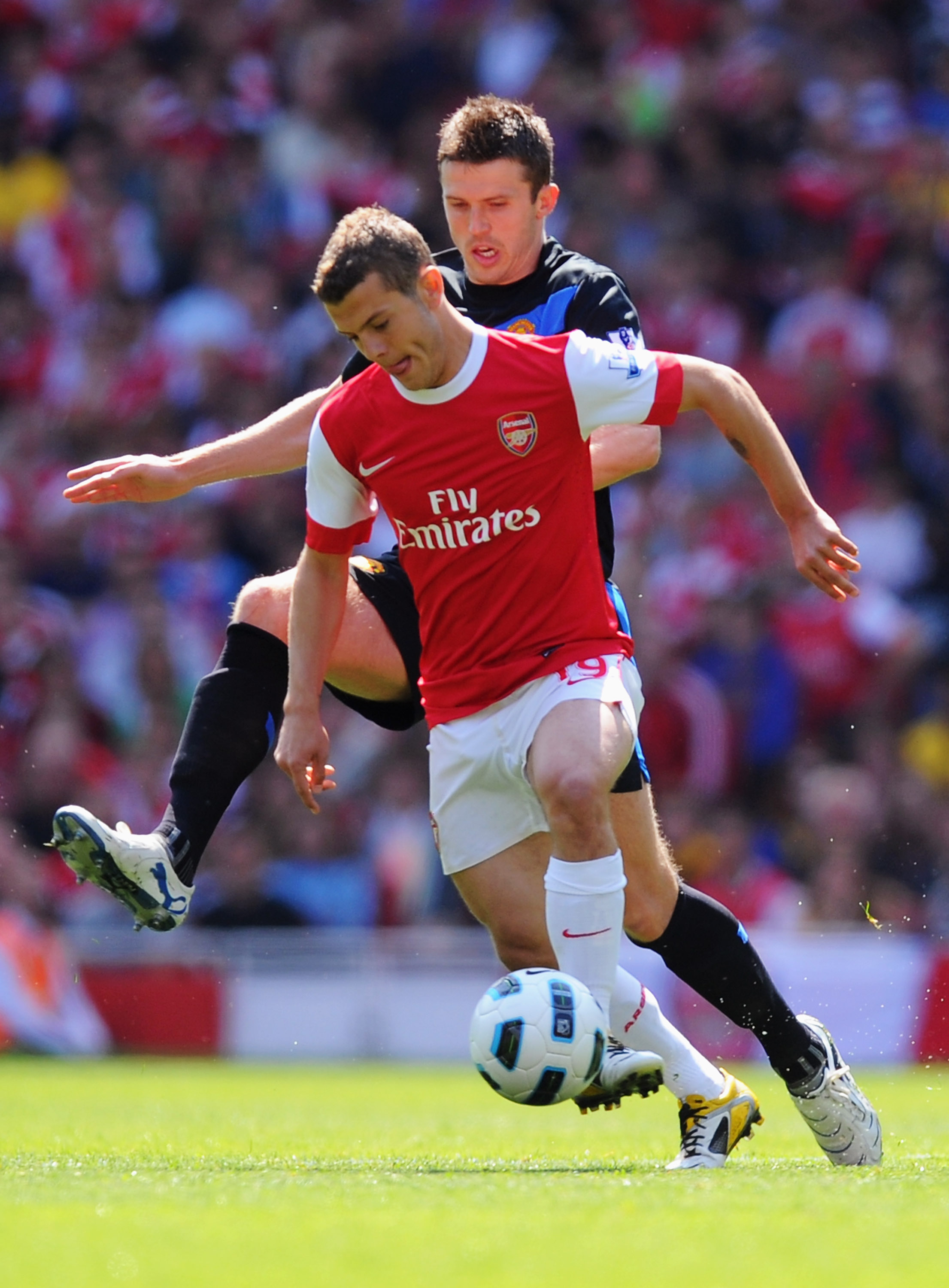 LONDON, ENGLAND - MAY 01:  Jack Wilshere of Arsenal holds off Michael Carrick of Manchester United during the Barclays Premier League match between Arsenal and Manchester United at the Emirates Stadium on May 1, 2011 in London, England.  (Photo by Mike He