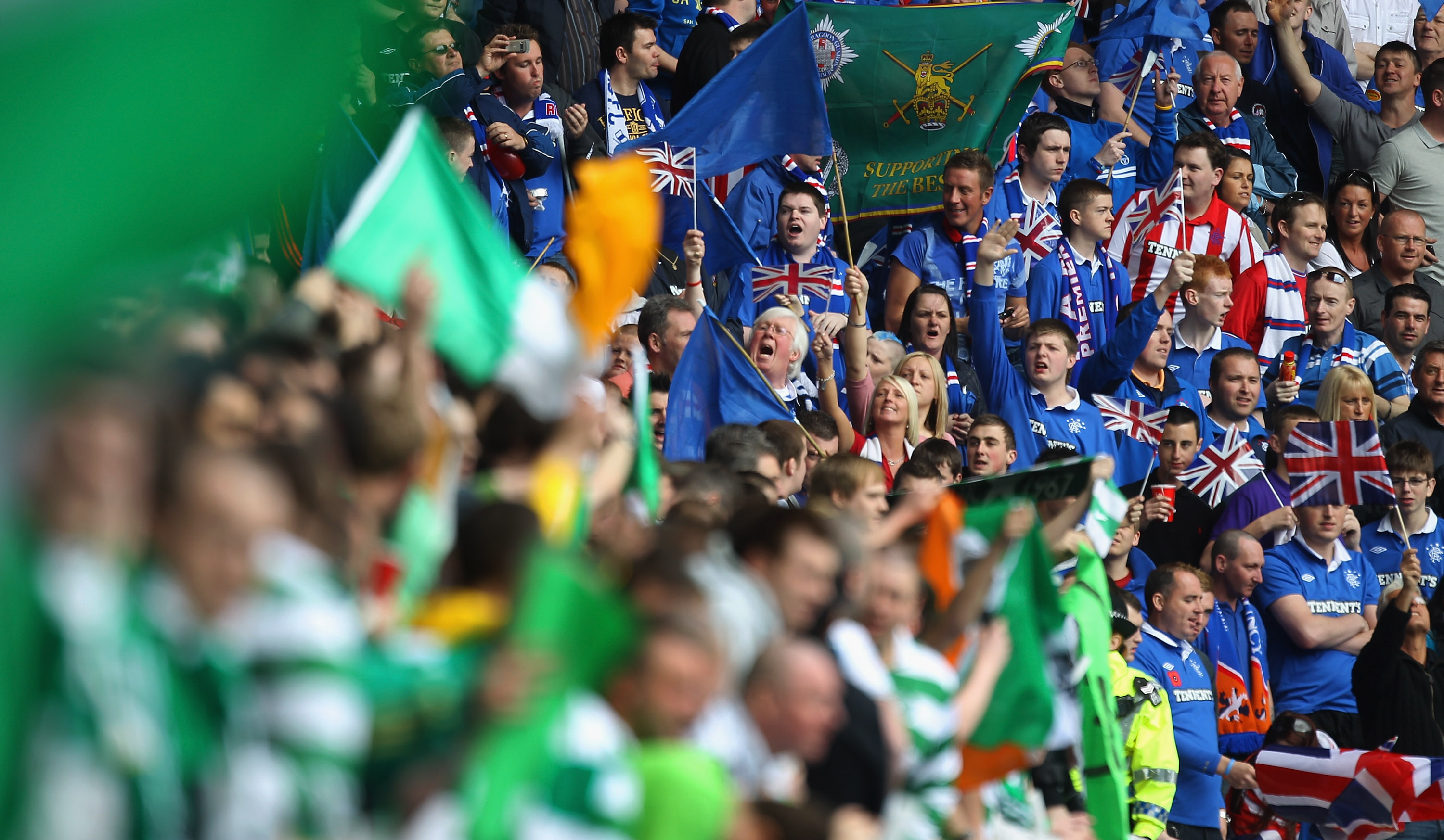 GLASGOW, SCOTLAND - APRIL 24:  Rangers and Celtic supporters chant before the Clydesdale Bank Premier League match between Rangers and Celtic at Ibrox Stadium on April 24, 2011 in Glasgow, Scotland.  (Photo by Jeff J Mitchell/Getty Images)
