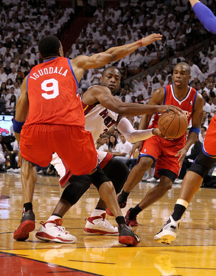 MIAMI, FL - APRIL 18:  Dwyane Wade #3 of the Miami Heat passes around Andre Iguodala #9 of the Philadelphia 76ers during game two of the Eastern Conference Quarterfinals at American Airlines Arena on April 18, 2011 in Miami, Florida. NOTE TO USER: User ex