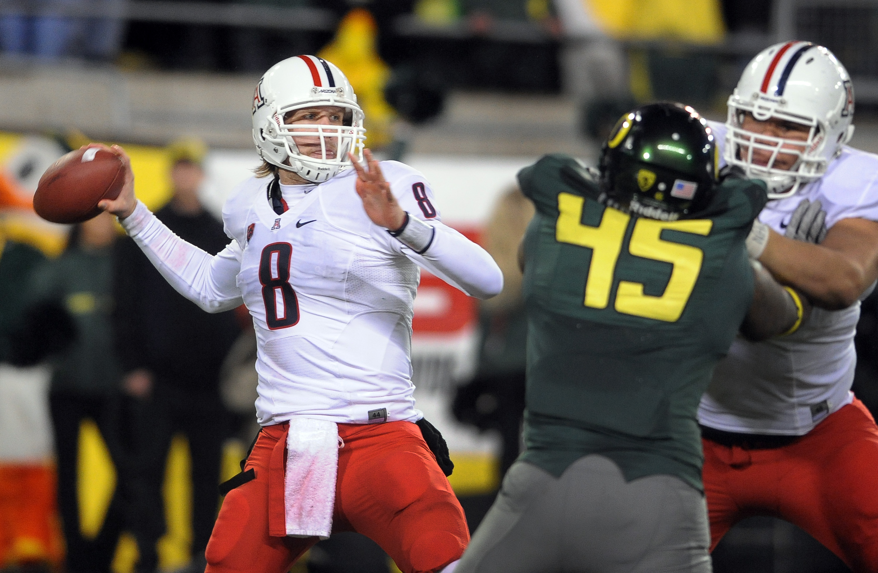 EUGENE, OR - NOVEMBER 26: Quarterback Nick Foles #8 of the Arizona Wildcats passes the ball as defensive end Terrell Turner #45 of the Oregon Ducks applies pressure in the fourth quarter of the game at Autzen Stadium on November 26, 2010 in Eugene, Oregon