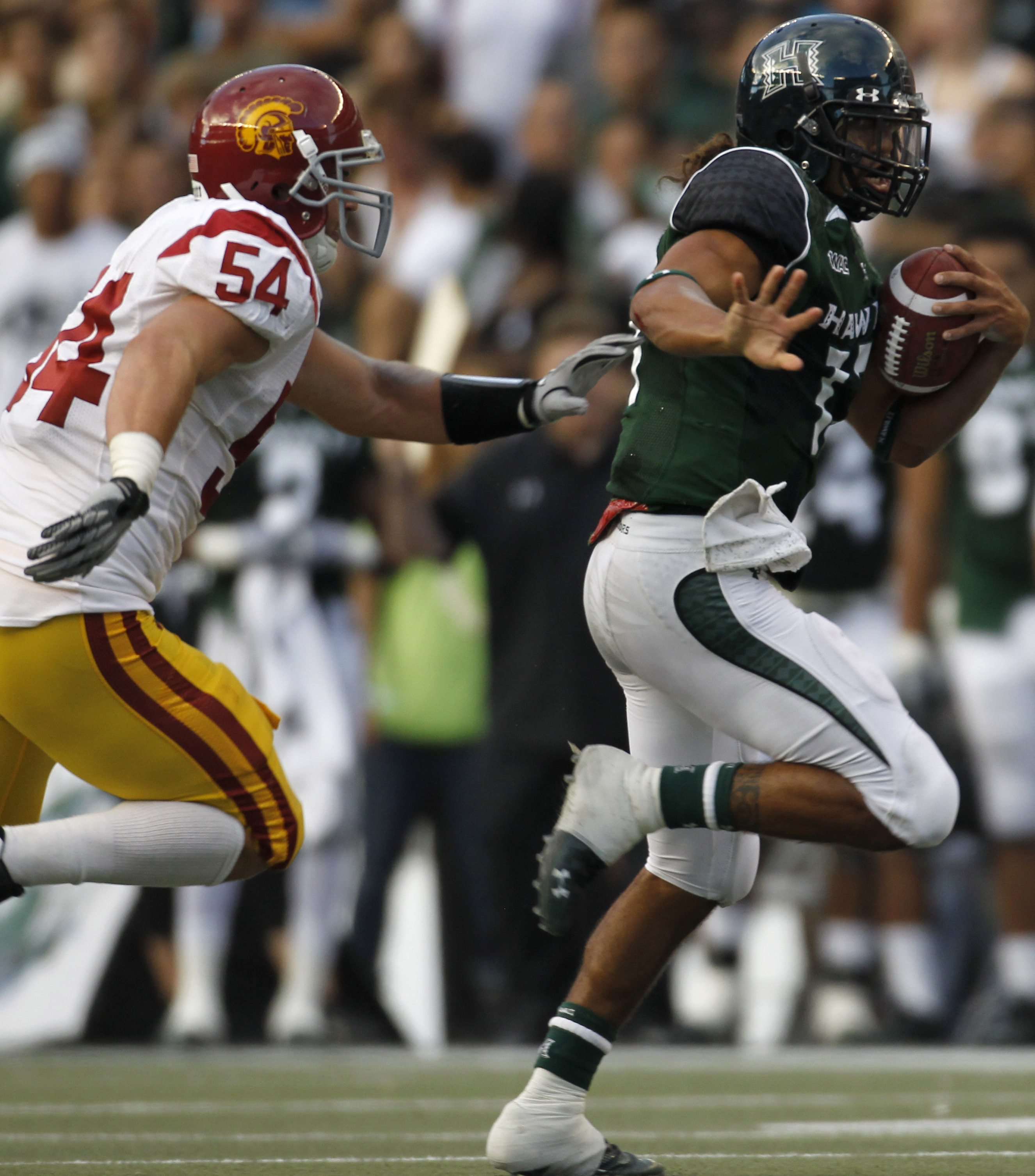 HONOLULU - SEPTEMBER 02: Quarterback Bryant Moniz #17 of the University of Hawaii Warriors is chased by Chris Galippo #54 of the University of Southern California Trojans as he carries the ball during first half action against the University of Southern C