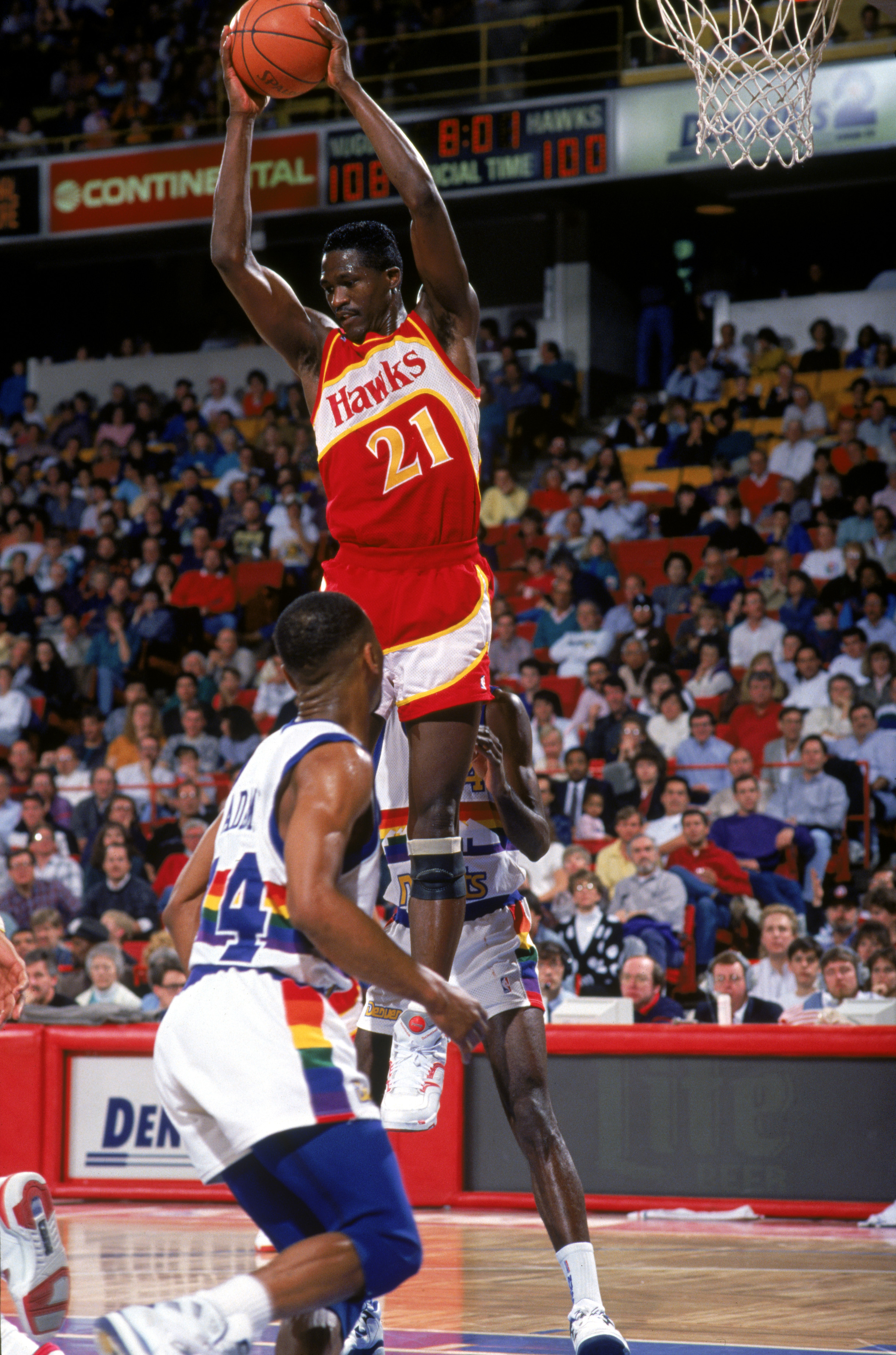 1990:  Dominique Wilkins #21 of the Atlanta Hawks collects a rebound during a 1990-1991 NBA season game against the Denver Nuggets.  (Photo by Tim DeFrisco/Getty Images)