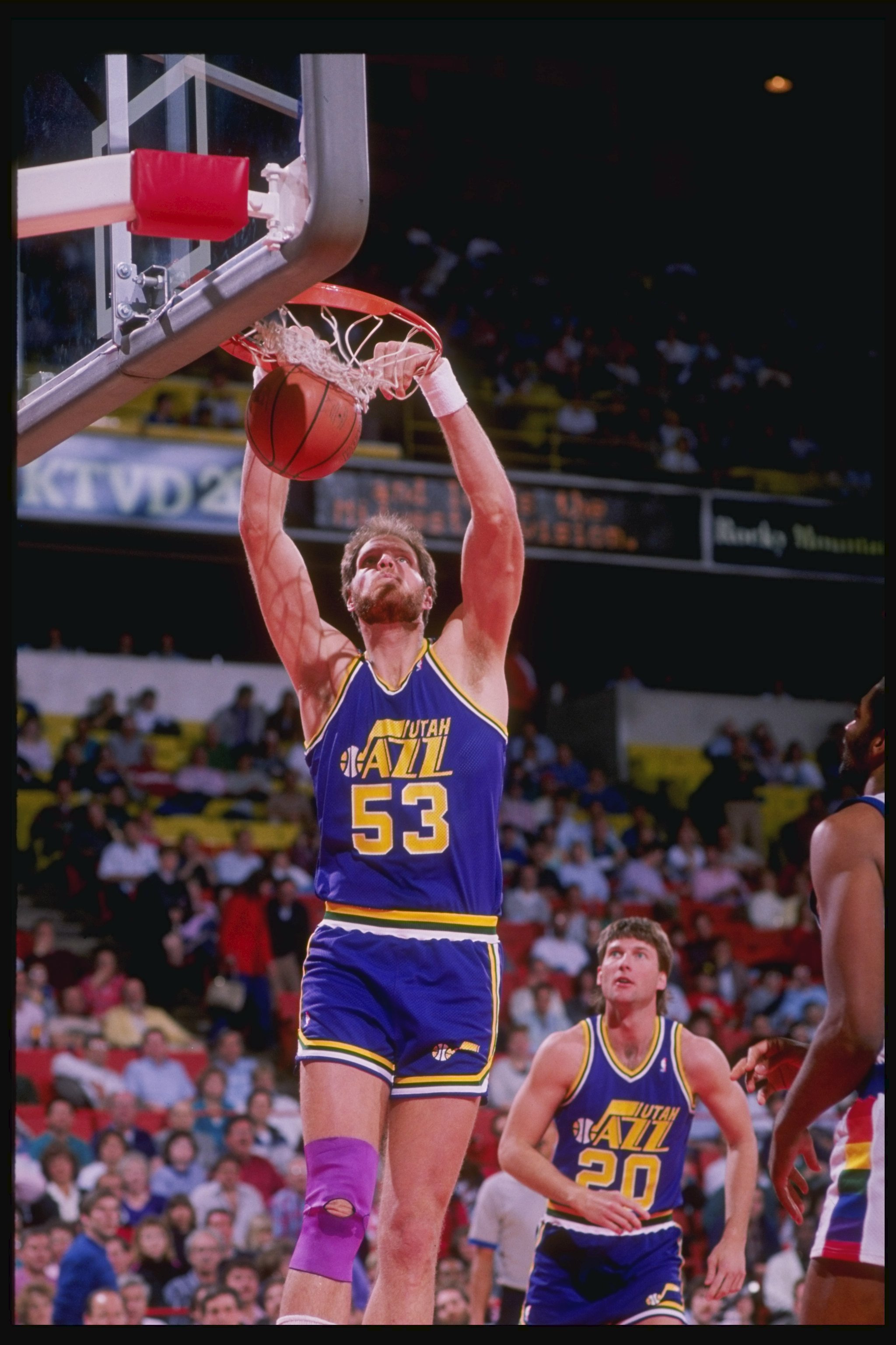 1989-1990:  Center Mark Eaton of the Utah Jazz slam dunks as teammate guard Bobby Hansen (right) looks on during a game against the Denver Nuggets at McNichols Arena in Denver, Colorado. Mandatory Credit: Tim de Frisco  /Allsport