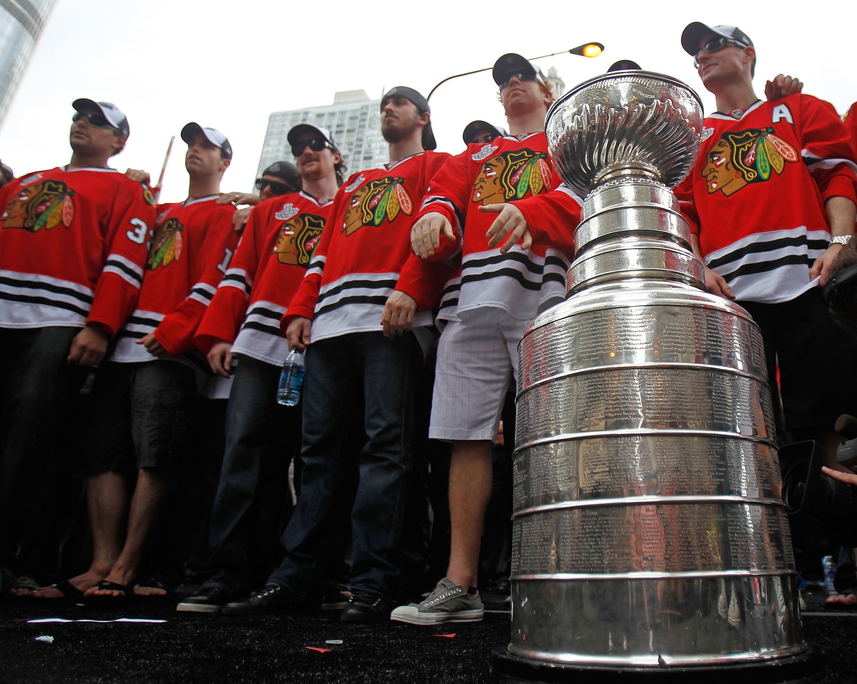 CHICAGO - JUNE 11: Members of the Chicago Blackhawks stand with the Stanley Cup during the Chicago Blackhawks Stanley Cup victory parade and rally on June 11, 2010 in Chicago, Illinois. (Photo by Jonathan Daniel/Getty Images)