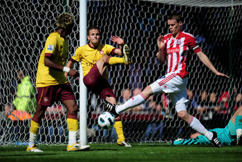 STOKE ON TRENT, ENGLAND - MAY 08:  Jack Wilshere of Arsenal clears the ball off his own goal line as Ryan Shawcross of Stoke closes in during the Barclays Premier League match between Stoke City and Arsenal at the Britannia Stadium on May 8, 2011 in Stoke