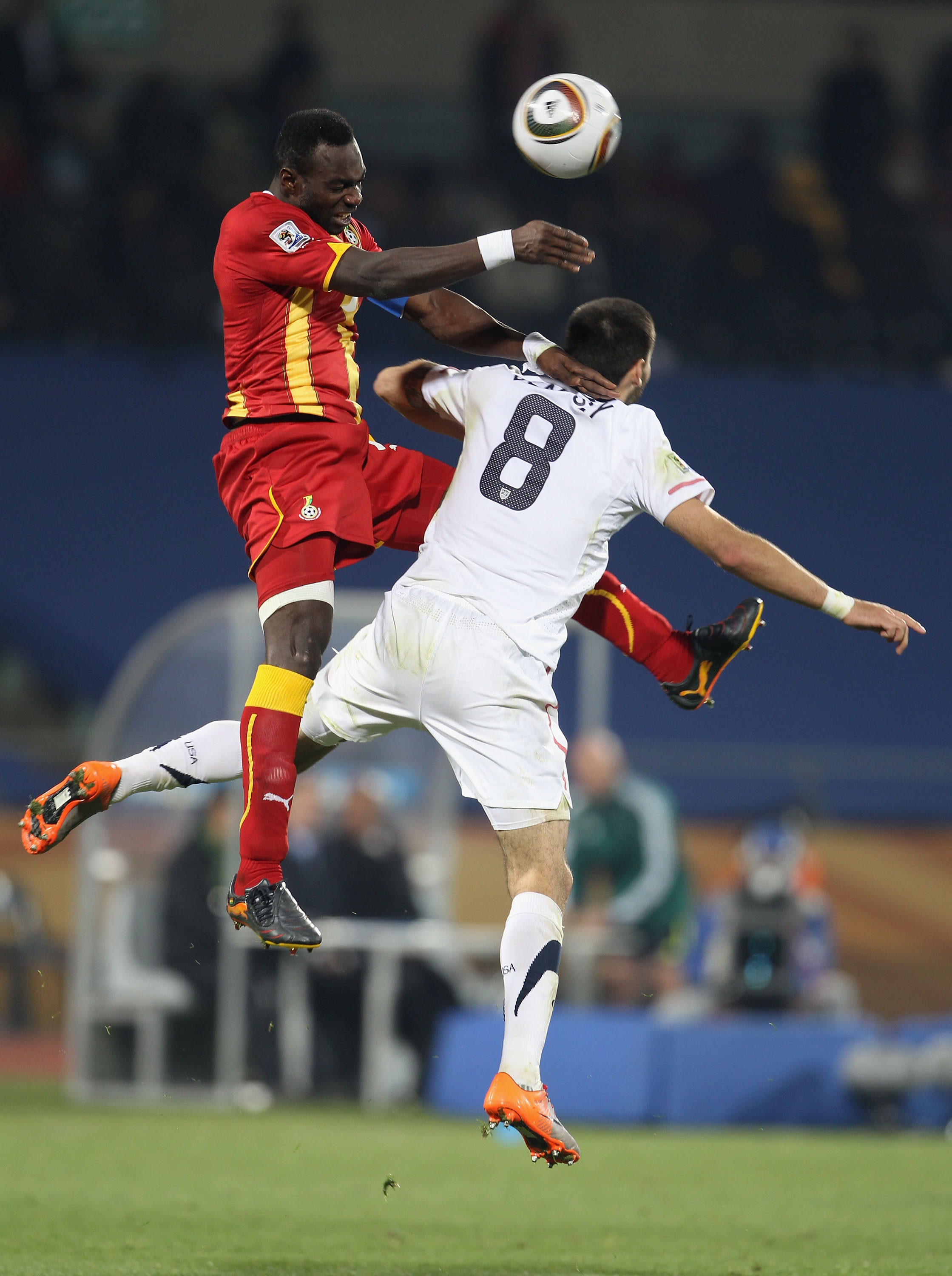 RUSTENBURG, SOUTH AFRICA - JUNE 26:  John Mensah of Ghana and Clint Dempsey of the United States jump for the ball during the 2010 FIFA World Cup South Africa Round of Sixteen match between USA and Ghana at Royal Bafokeng Stadium on June 26, 2010 in Ruste