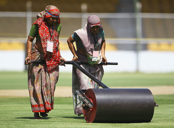 AHMEDABAD, INDIA - MARCH 22: Women Groundstaff roll out the pitch during a India Nets Session at the Sardar Patel Gujarat Stadium on March 22, 2011 in Ahmedabad, India. (Photo by Matthew Lewis/Getty Images)
