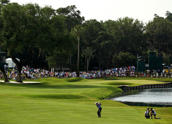 PONTE VEDRA BEACH, FL - MAY 13:  Phil Mickelson hits a shot on the 16th hole as his caddie Jim Mackay looks on during the second round of THE PLAYERS Championship held at THE PLAYERS Stadium course at TPC Sawgrass on May 13, 2011 in Ponte Vedra Beach, Flo