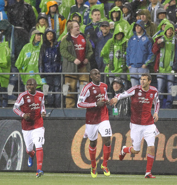 SEATTLE - MAY 14:  Mamadou Danso #98 (C) of the Portland Timbers celebrates with Eric Brunner #5 (R) and Kalif Alhassan #11 after scoring a goal against the Seattle Sounders FC at Qwest Field on May 14, 2011 in Seattle, Washington. The Sounders and Timber