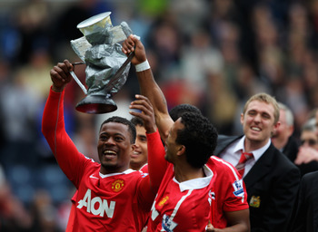 BLACKBURN, ENGLAND - MAY 14:  Patrice Evra (L) and Nani of Manchester United hold up a blow up trophy after winning the Barclays Premier League match between Blackburn Rovers and Manchester United and sealing the title at Ewood park on May 14, 2011 in Bla