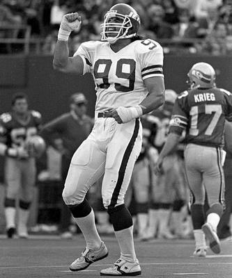 Defensive end Mark Gastineau of the New York Jets throws his hands in