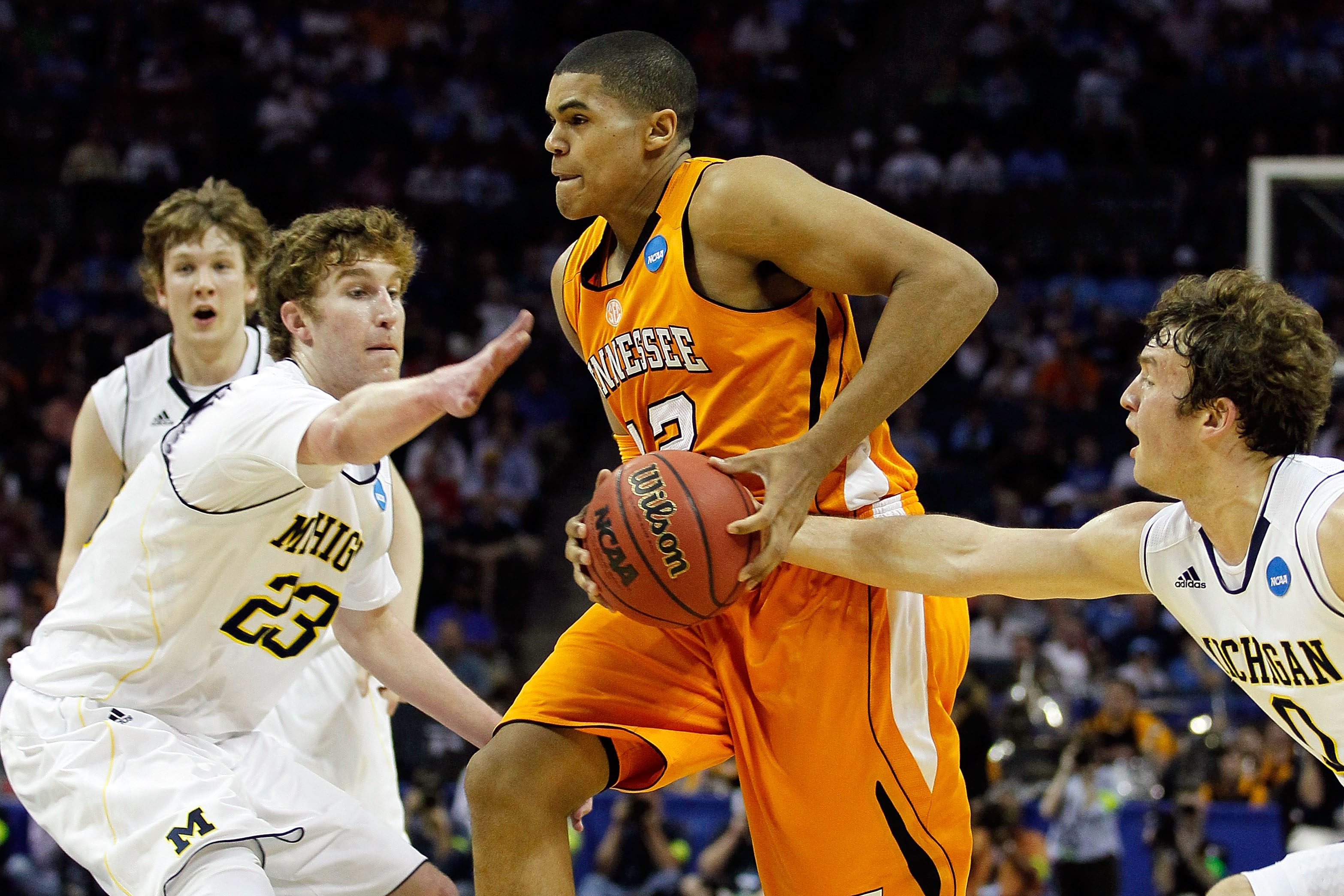 CHARLOTTE, NC - MARCH 18:  Tobias Harris #12 of the Tennessee Volunteers drives through Evan Smotrycz #23 and Zack Novak #0 of the Michigan Wolverines in the first half during the second round of the 2011 NCAA men's basketball tournament at Time Warner Ca