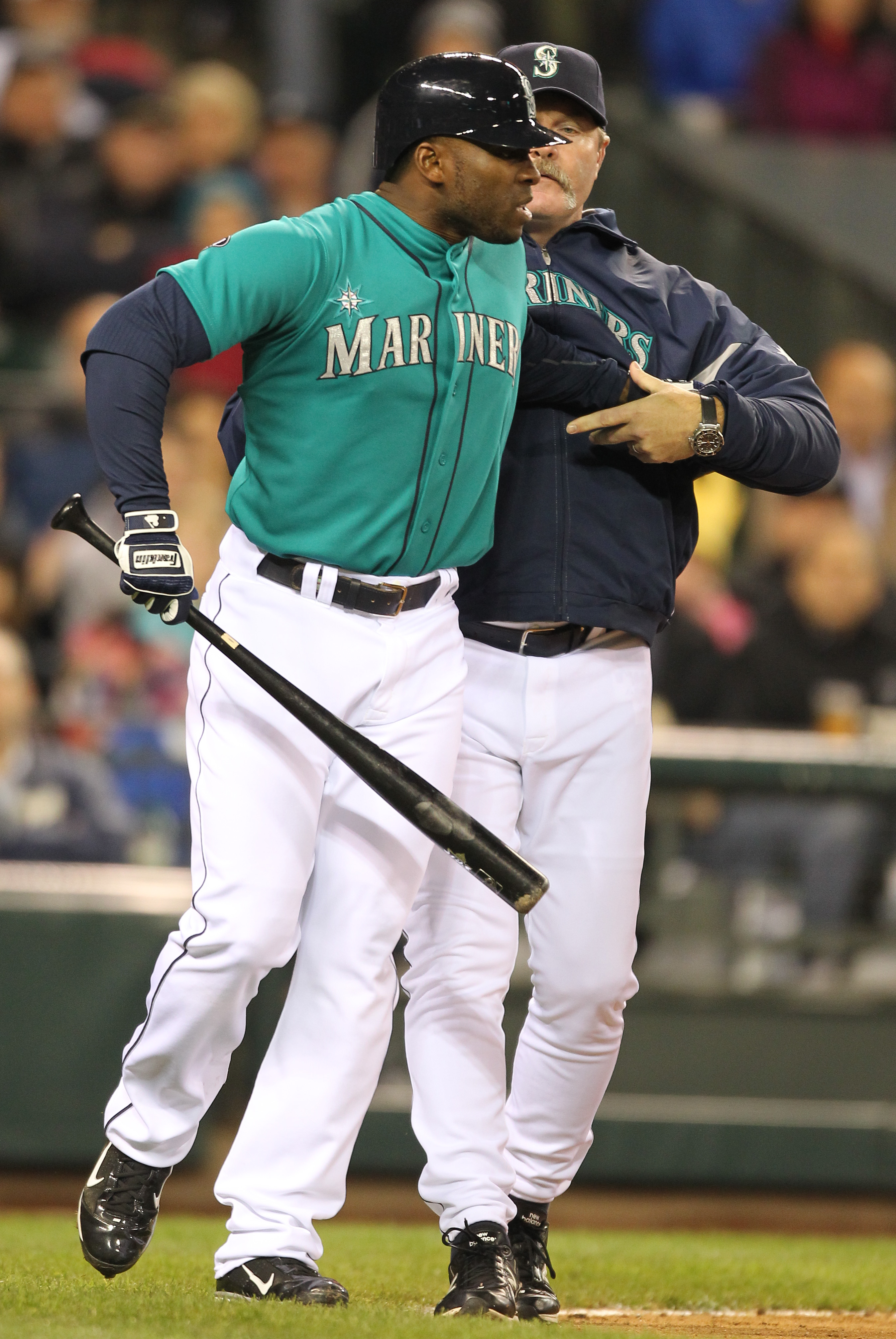 SEATTLE - MAY 06:  Milton Bradley #15 of the Seattle Mariners is restrained by manager Eric Wedge #22 after being ejected from the game against the Chicago White Sox at Safeco Field on May 6, 2011 in Seattle, Washington. The Mariners won 3-2. (Photo by Ot